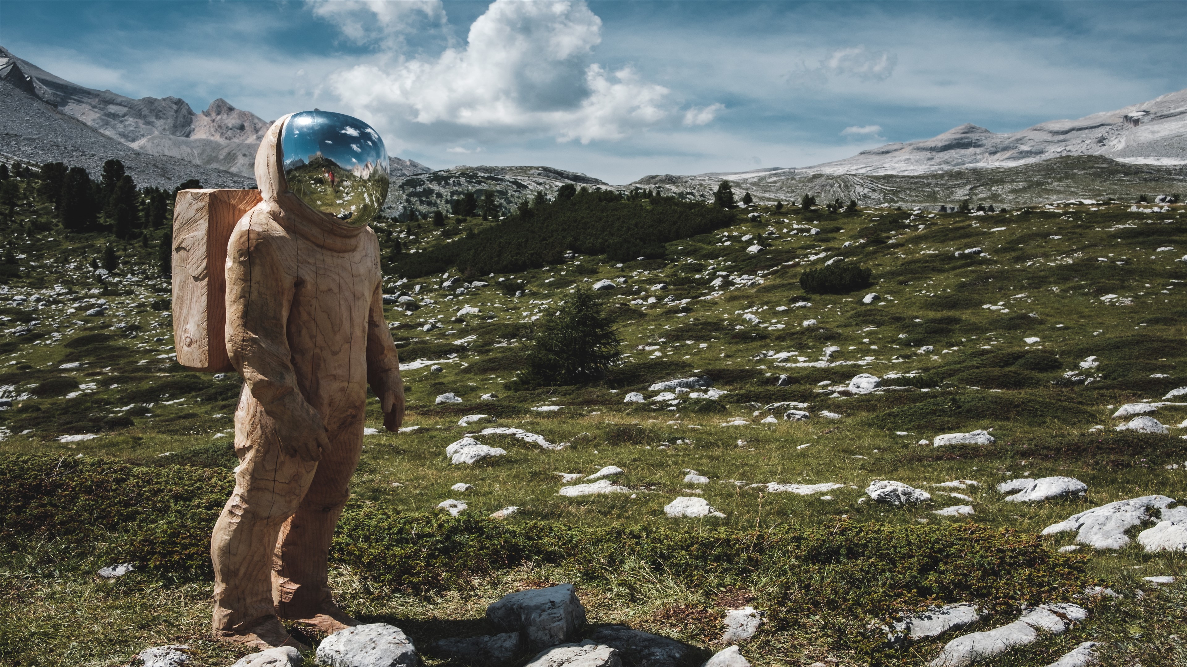 Wooden Astronaut Sculpture in Mountain Landscape 4K HD Wallpaper