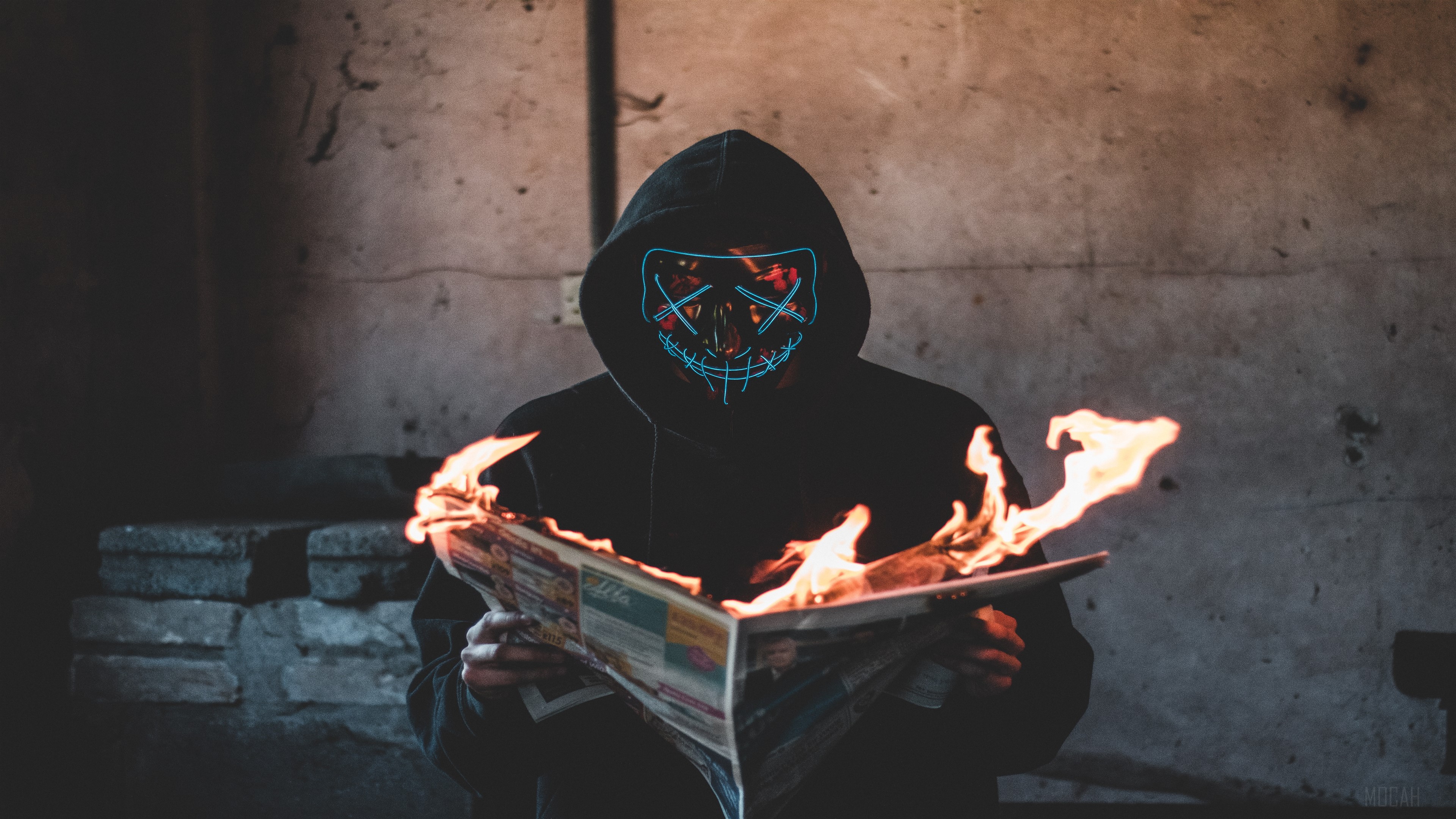 Masked person reading burning newspaper 4K HD Wallpaper