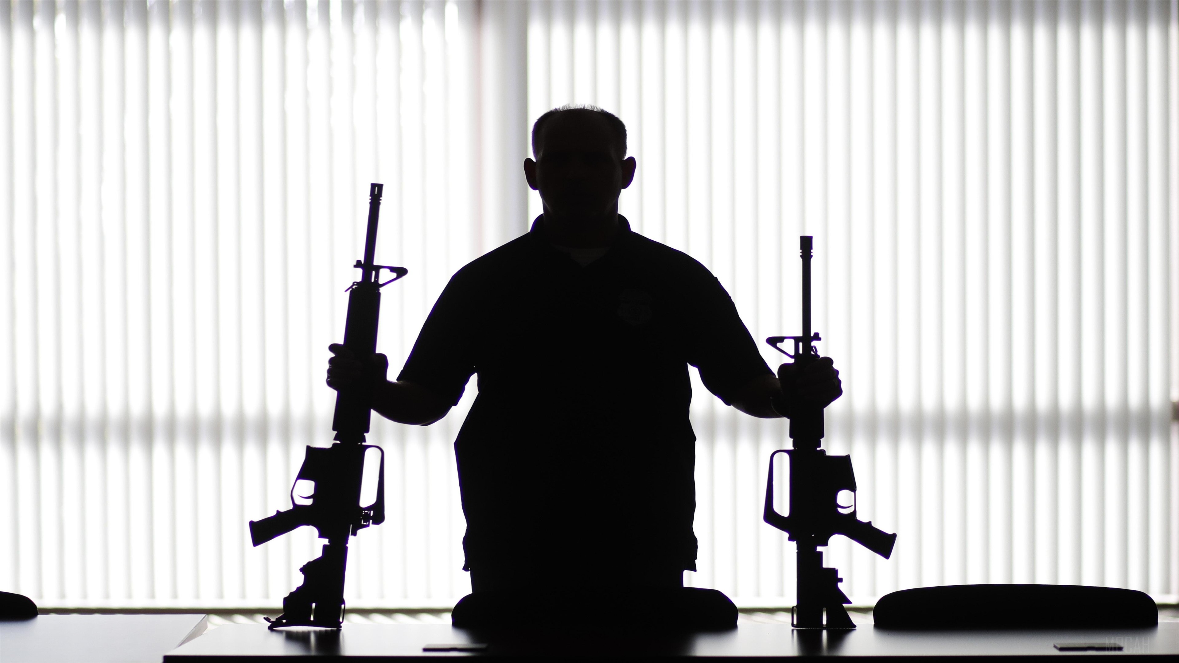 Man holding two rifles in silhouette HD Wallpaper