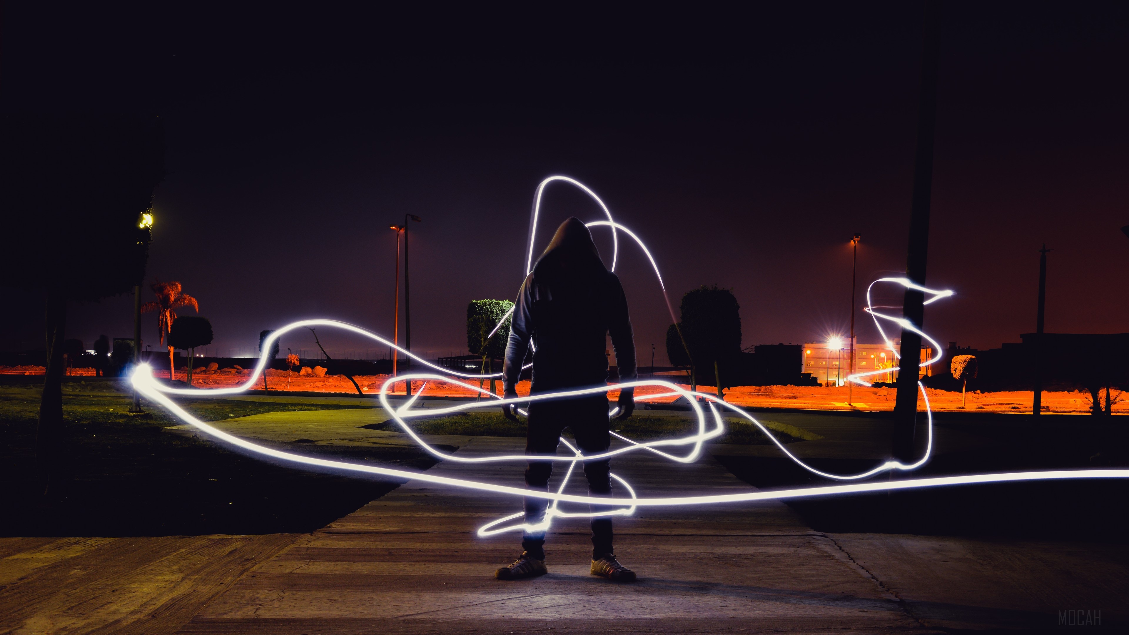 Person in hoodie with neon light painting at night HD Wallpaper