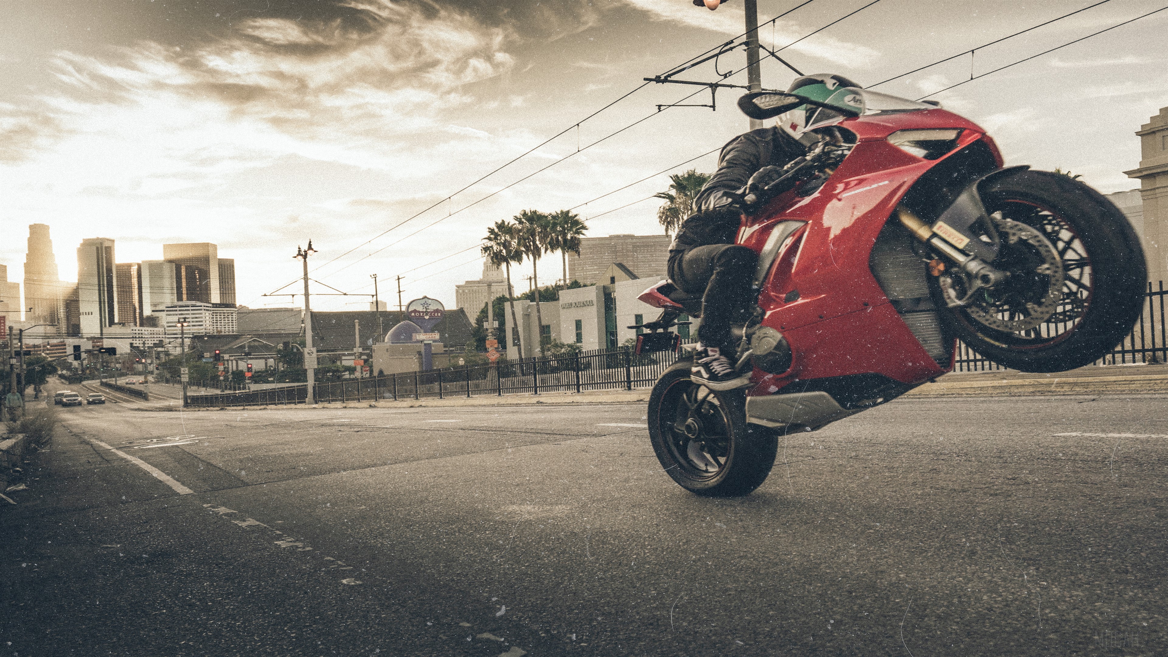 Red Ducati motorcycle doing a wheelie in Los Angeles 4K HD Wallpaper