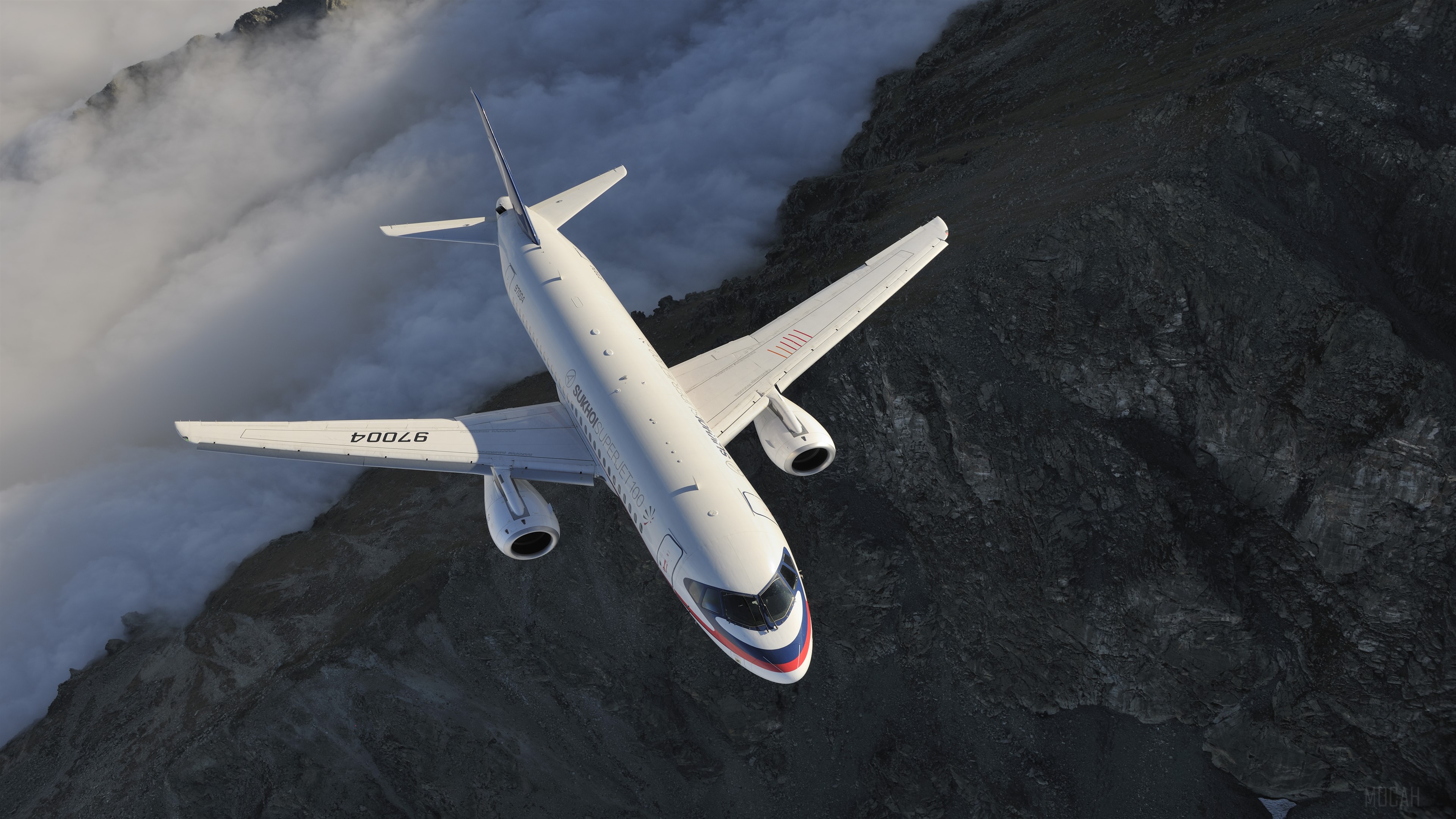 Sukhoi Superjet 100 passenger airplane flying over mountains HD Wallpaper