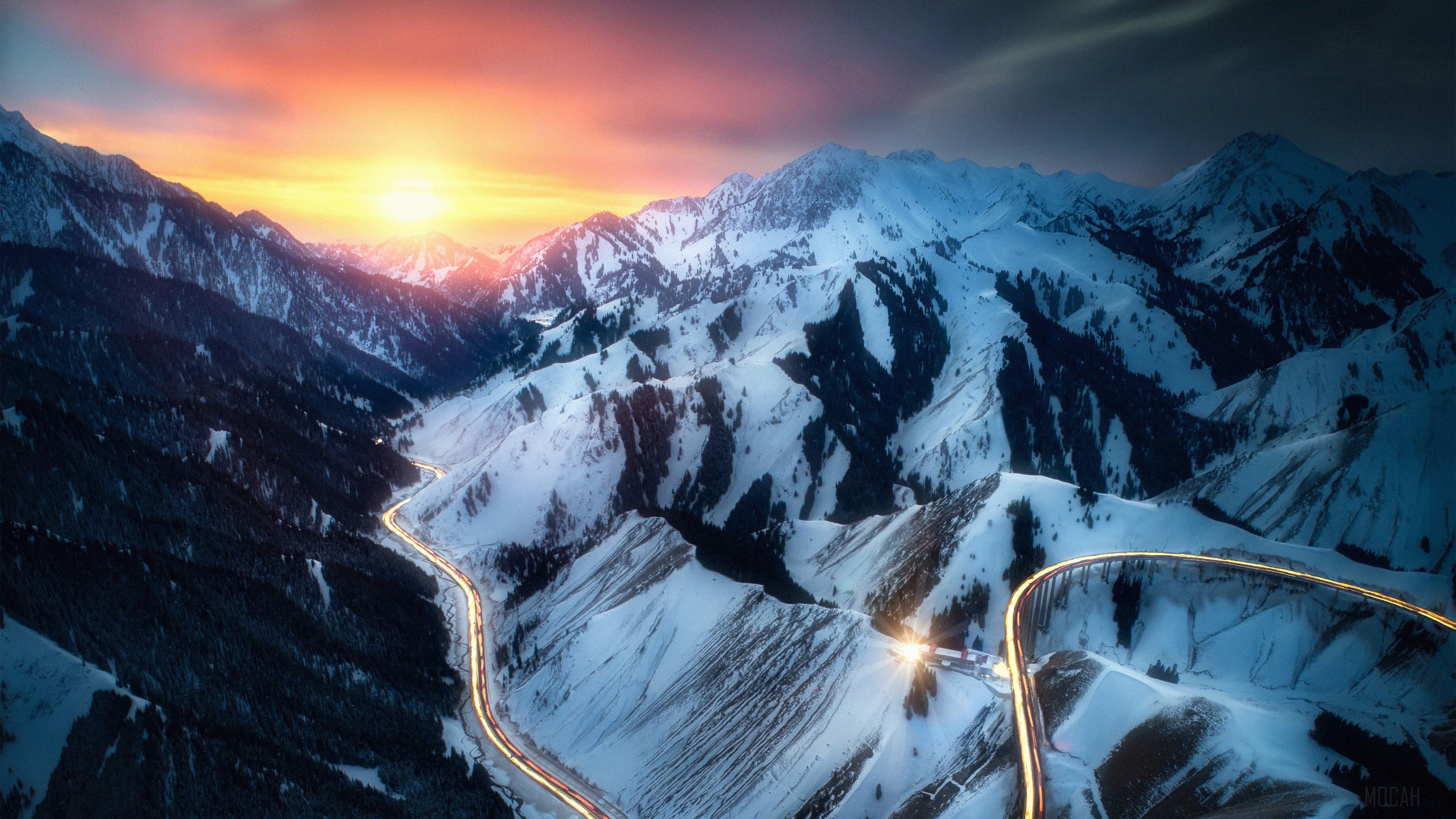 Road through snowy mountains at sunset with long exposure HD Wallpaper