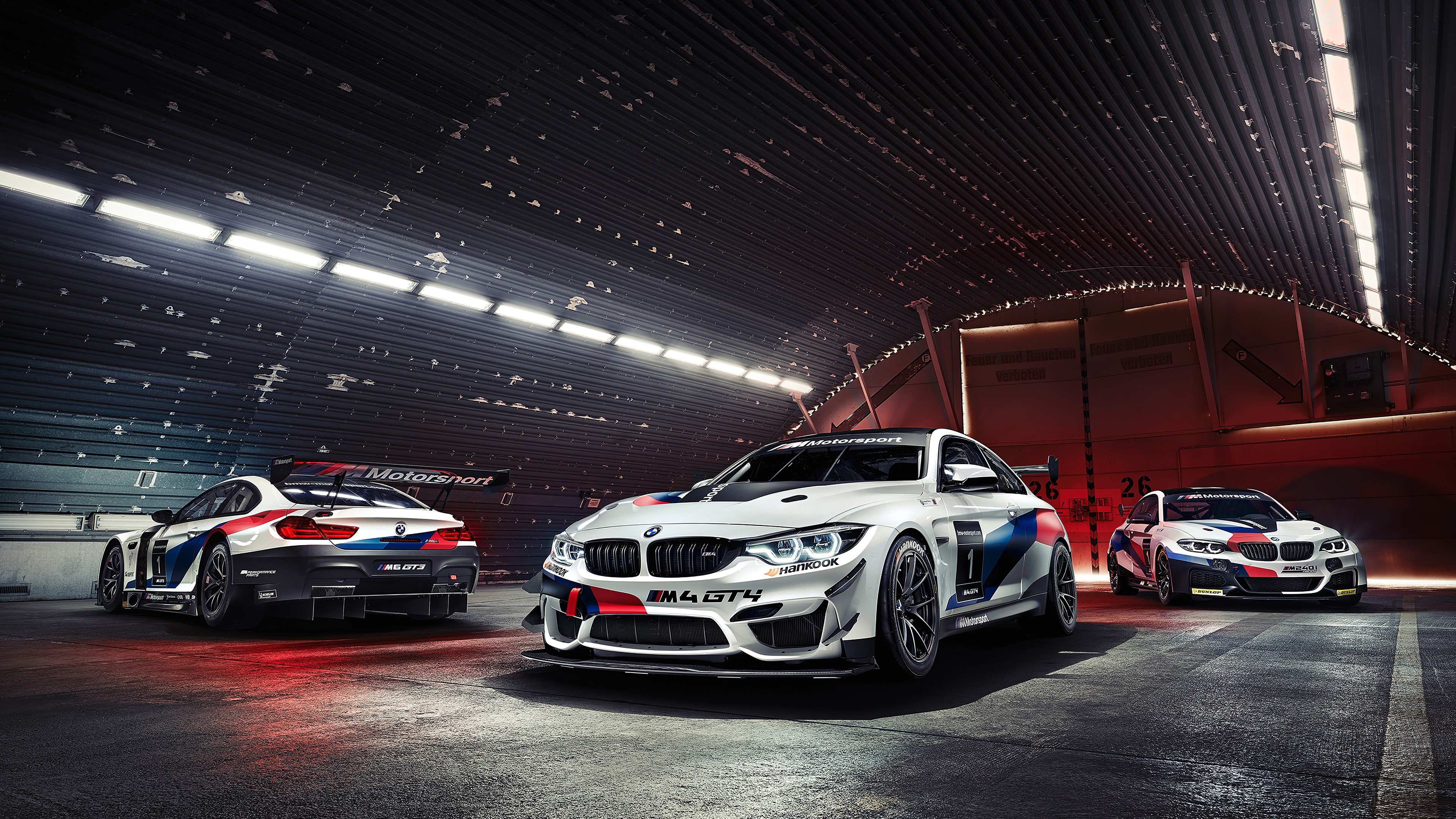 BMW M4 GT4 race cars in a garage HD Wallpaper
