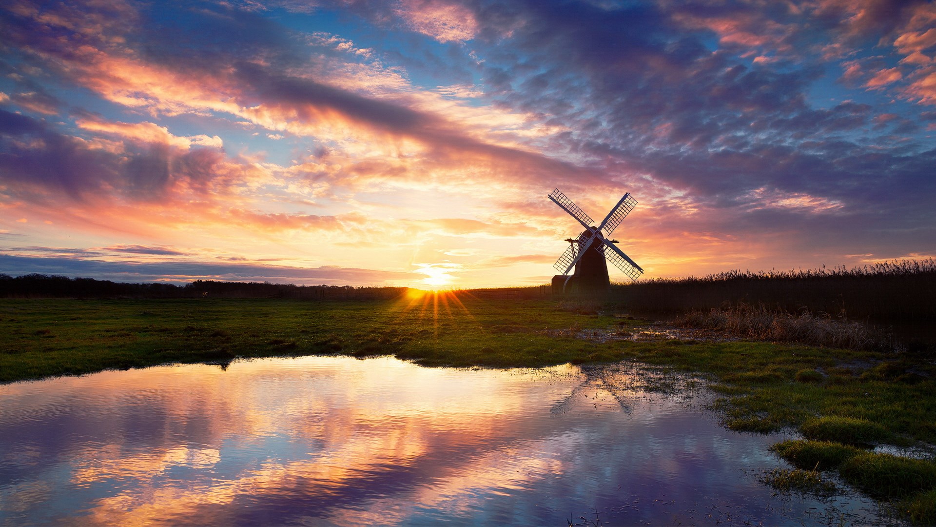 Windmill at sunset reflected in water HD Wallpaper