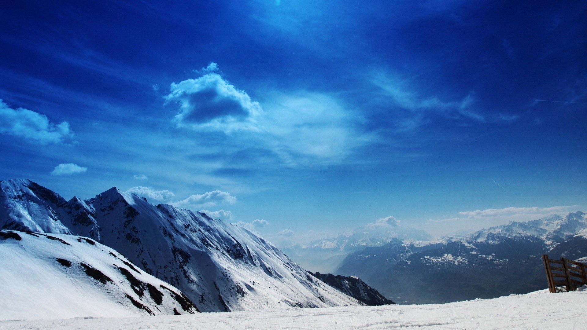 Snowy mountains under a blue sky with clouds HD Wallpaper