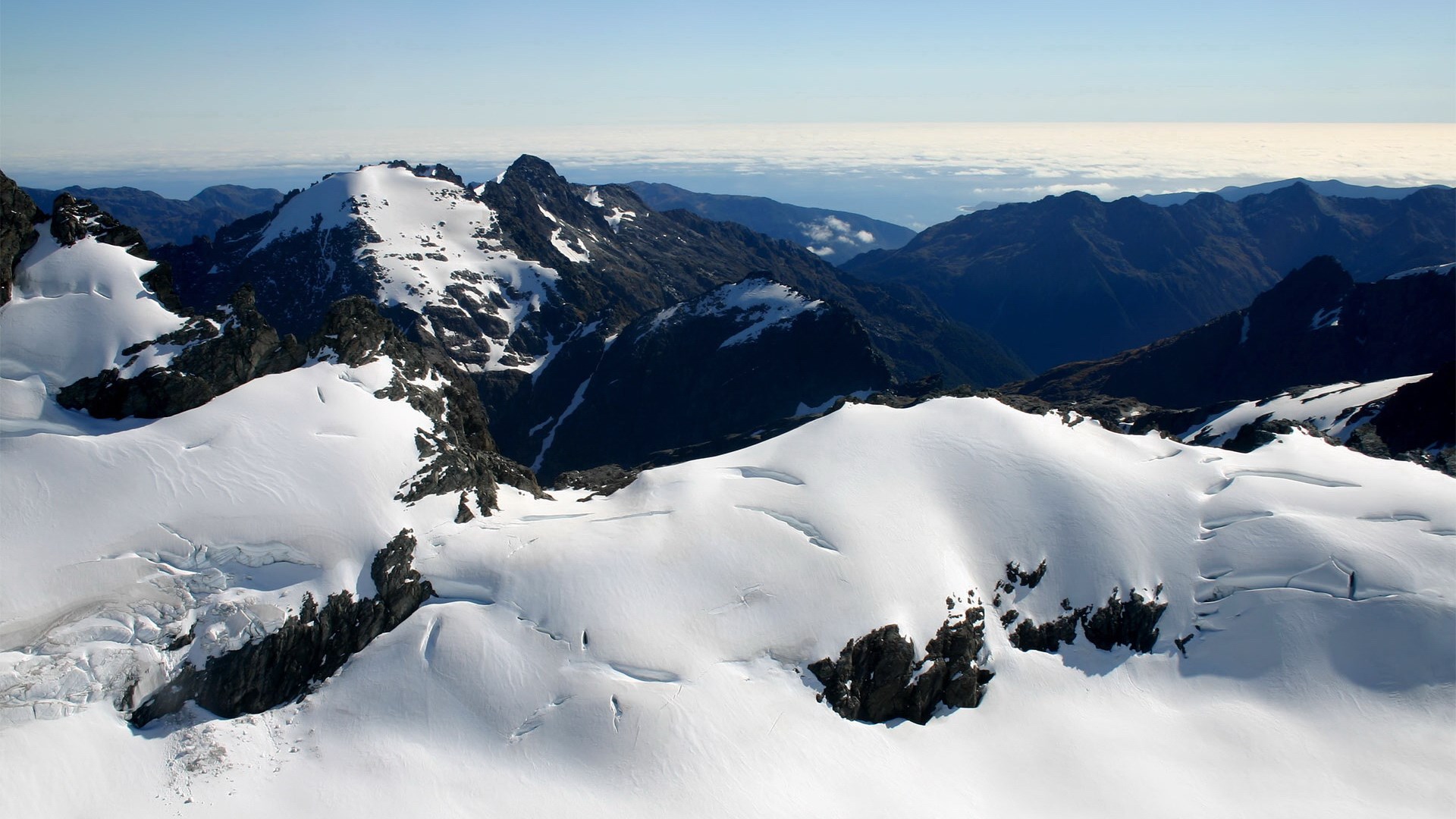 Snow-covered mountains under a clear sky HD Wallpaper