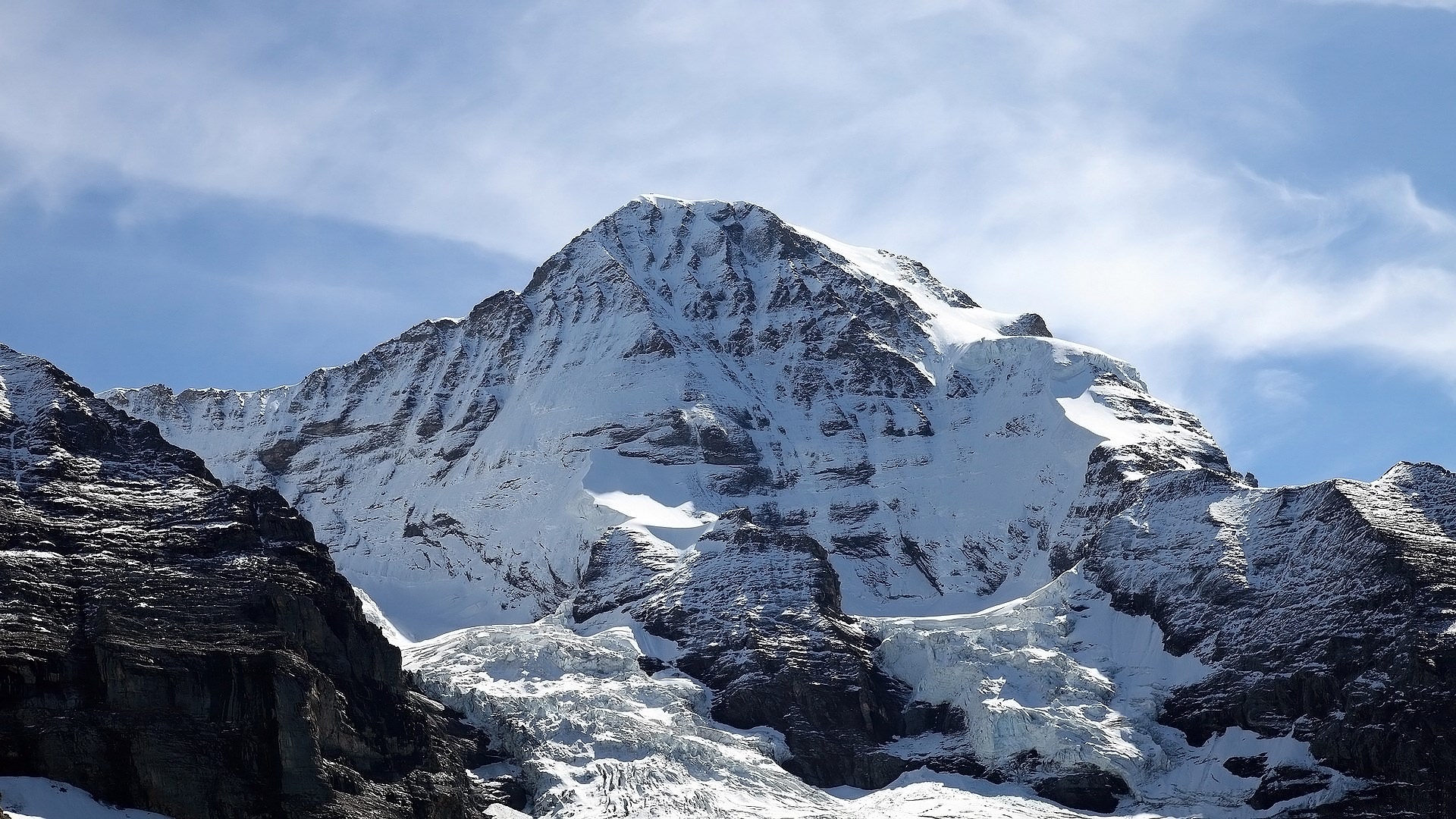 Snow-covered mountain peak under a blue sky HD Wallpaper