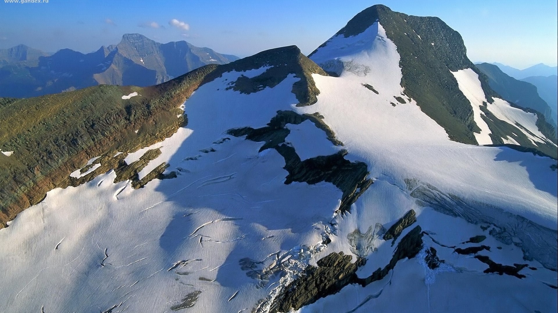 Snow-covered mountain peaks under a clear blue sky HD Wallpaper