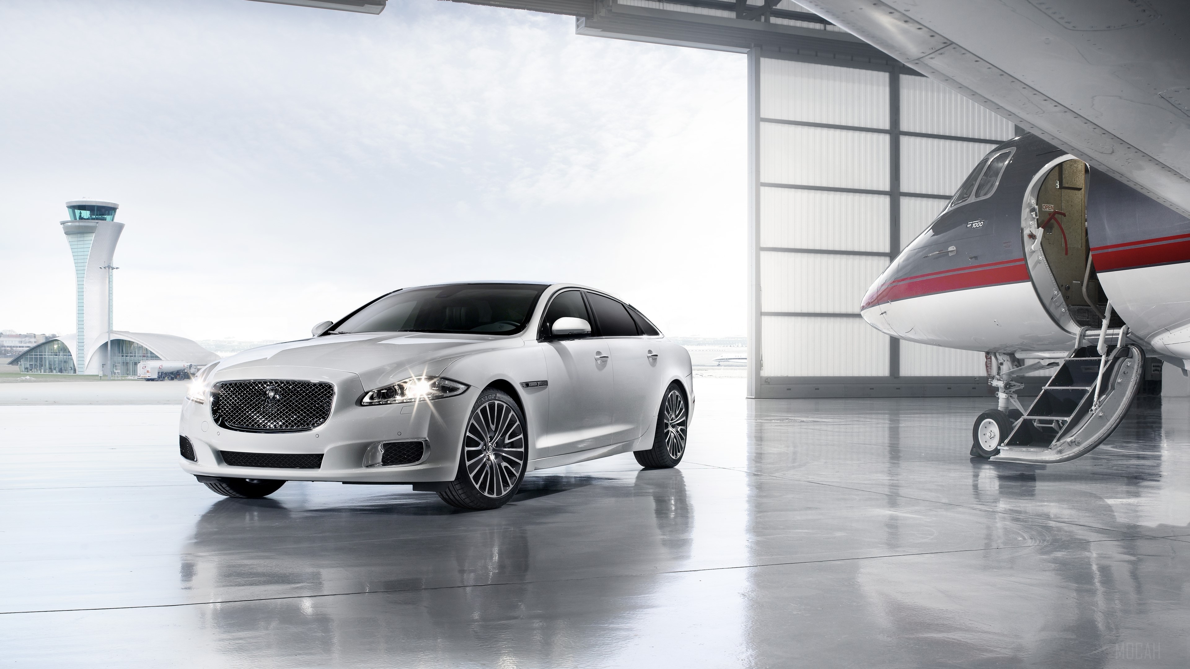 Jaguar XJ Ultimate 4K in hangar with private jet HD Wallpaper