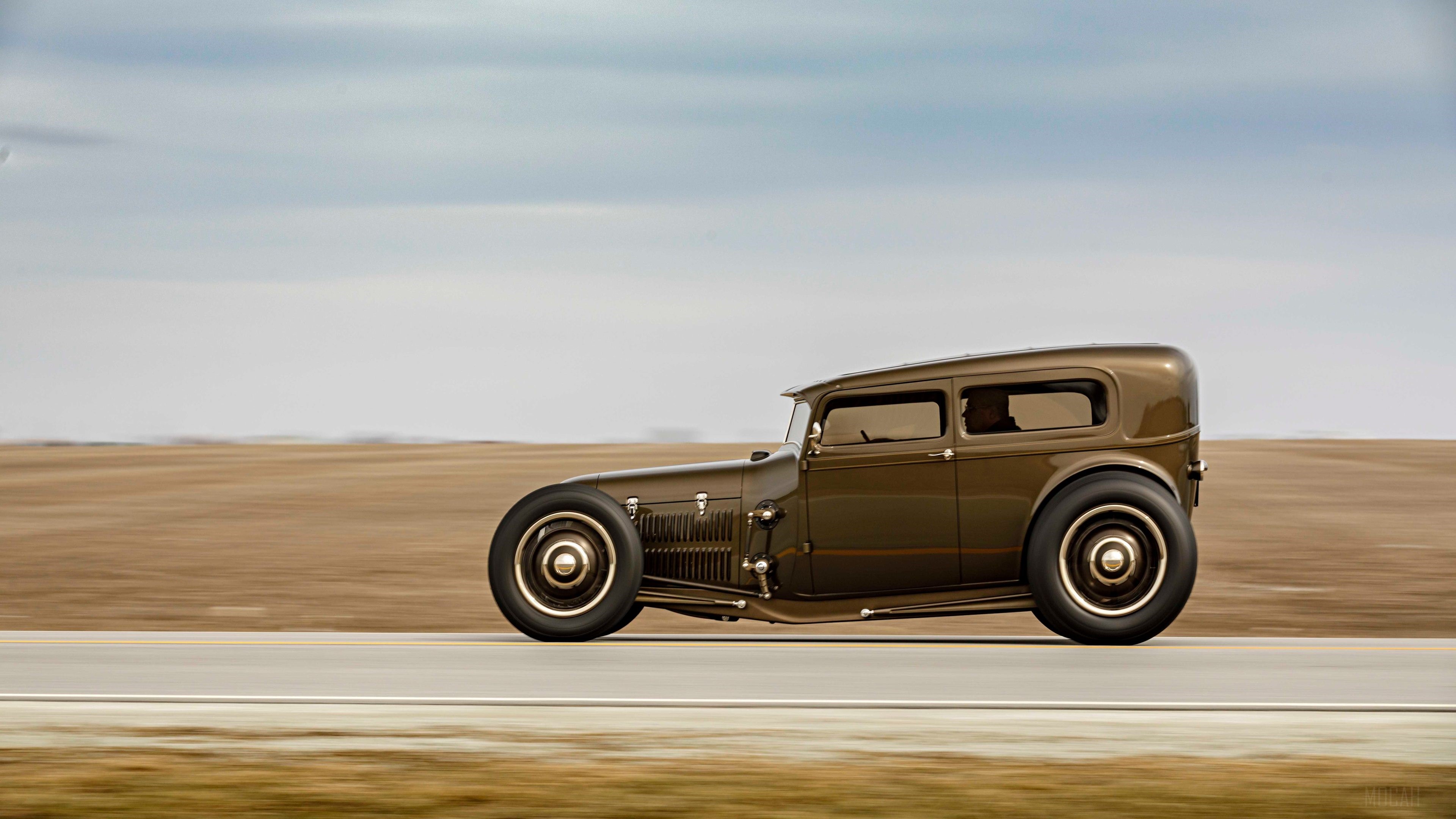 1929 Ford Highboy hot rod driving on a road HD Wallpaper