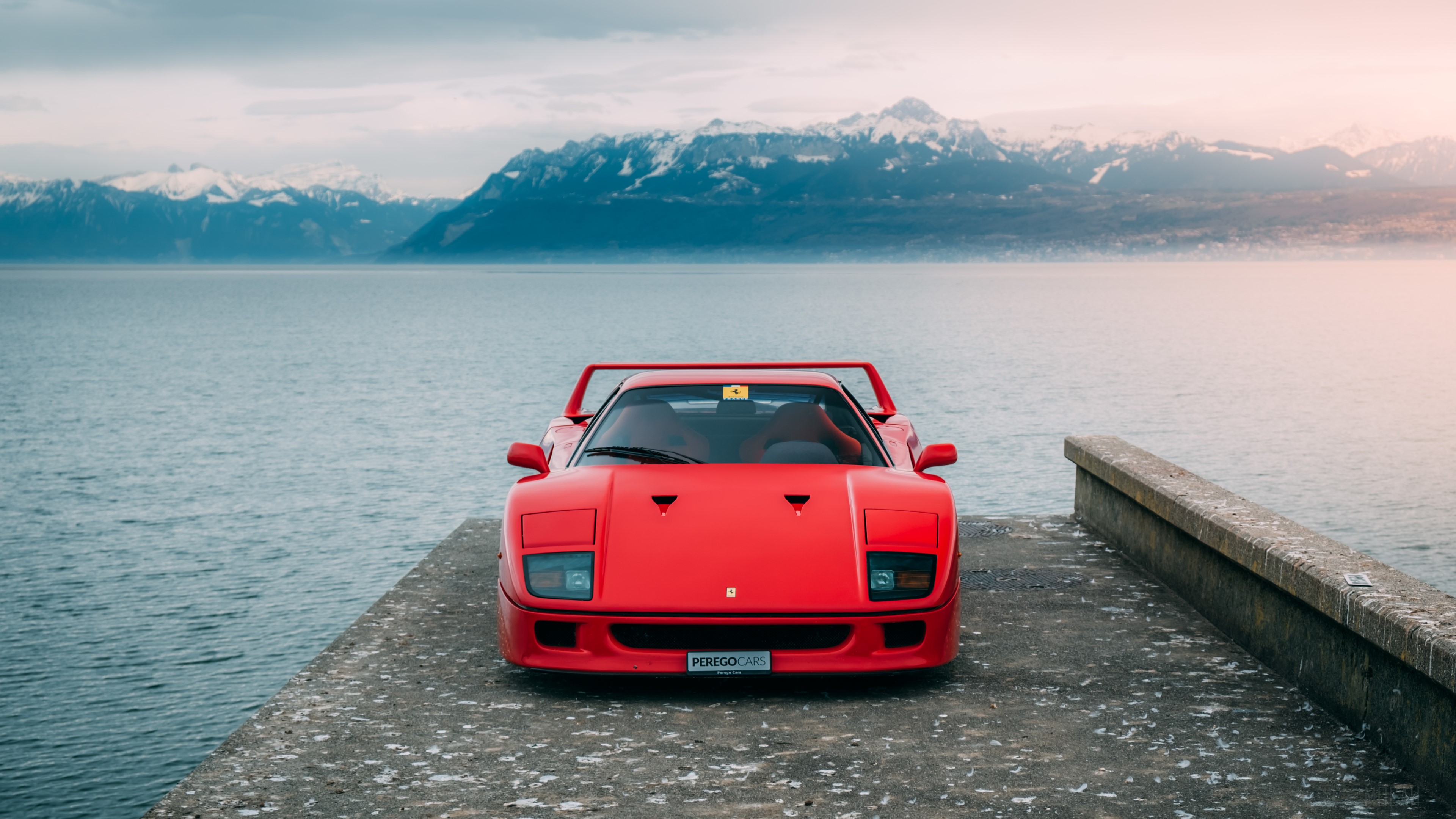 Red Ferrari F40 parked by a lake with mountains HD Wallpaper
