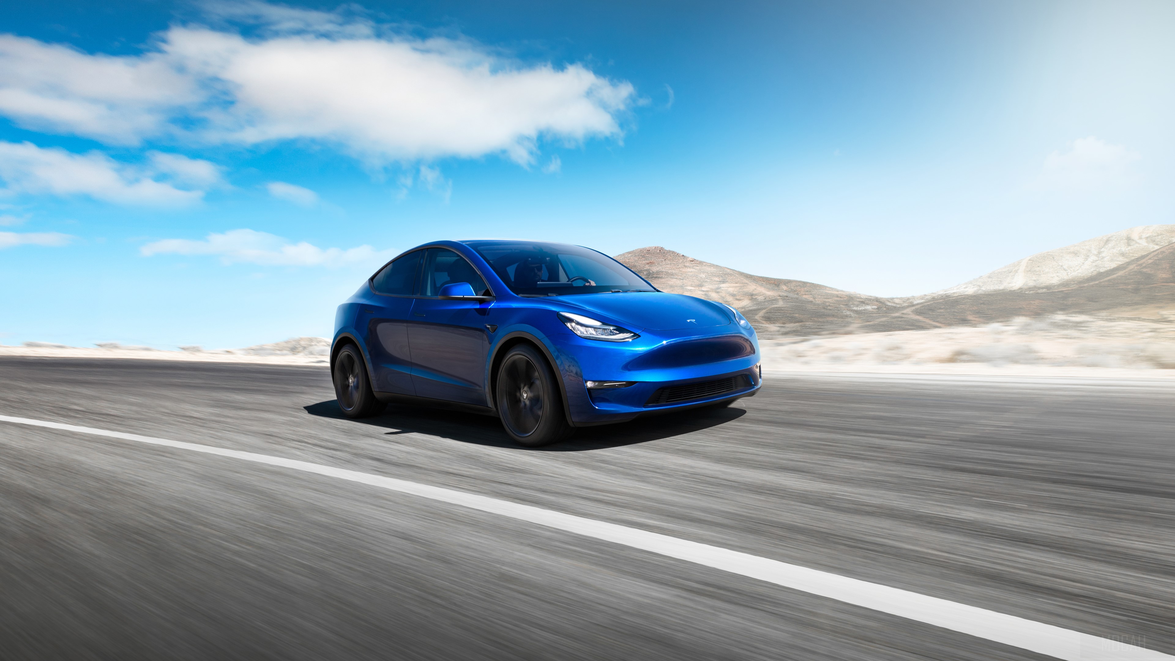 Blue 2019 Tesla Model Y driving on a road HD Wallpaper