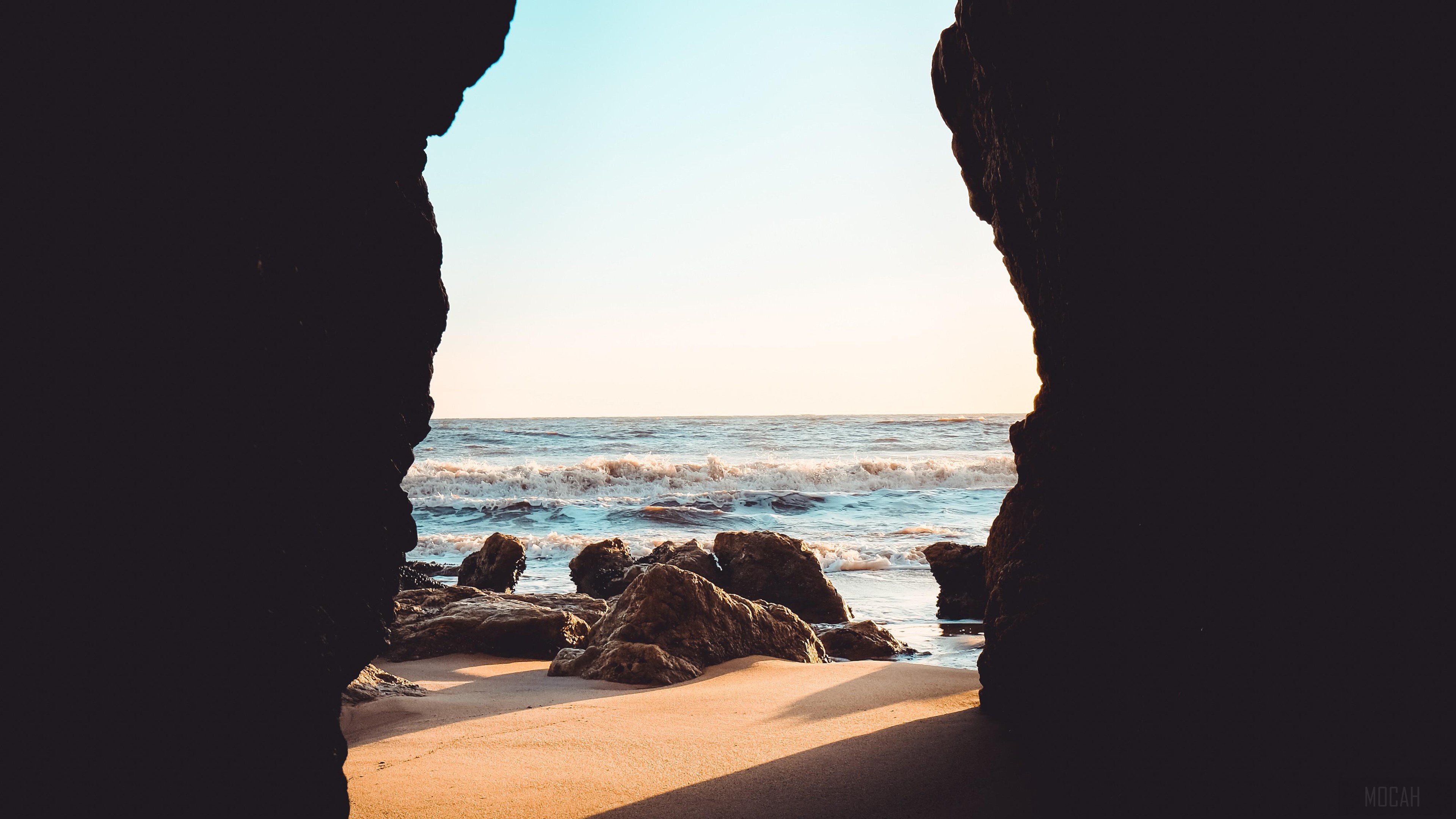 View of the ocean through a cave opening HD Wallpaper