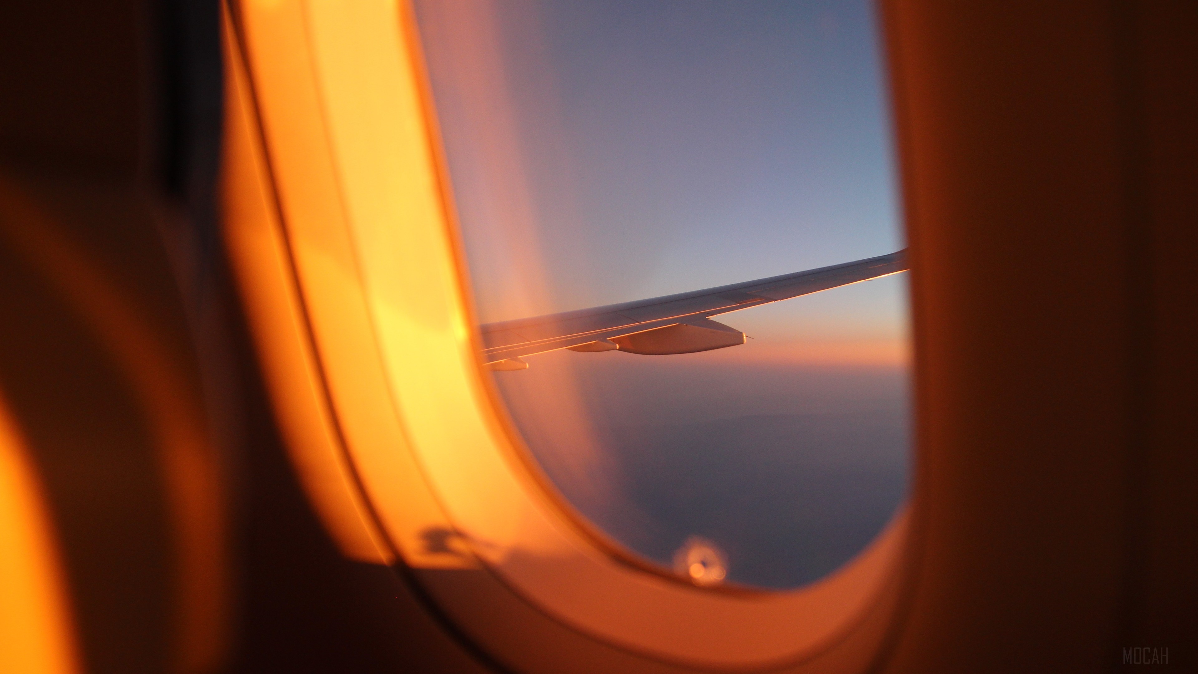 Airplane window view of wing at sunset 4K HD Wallpaper