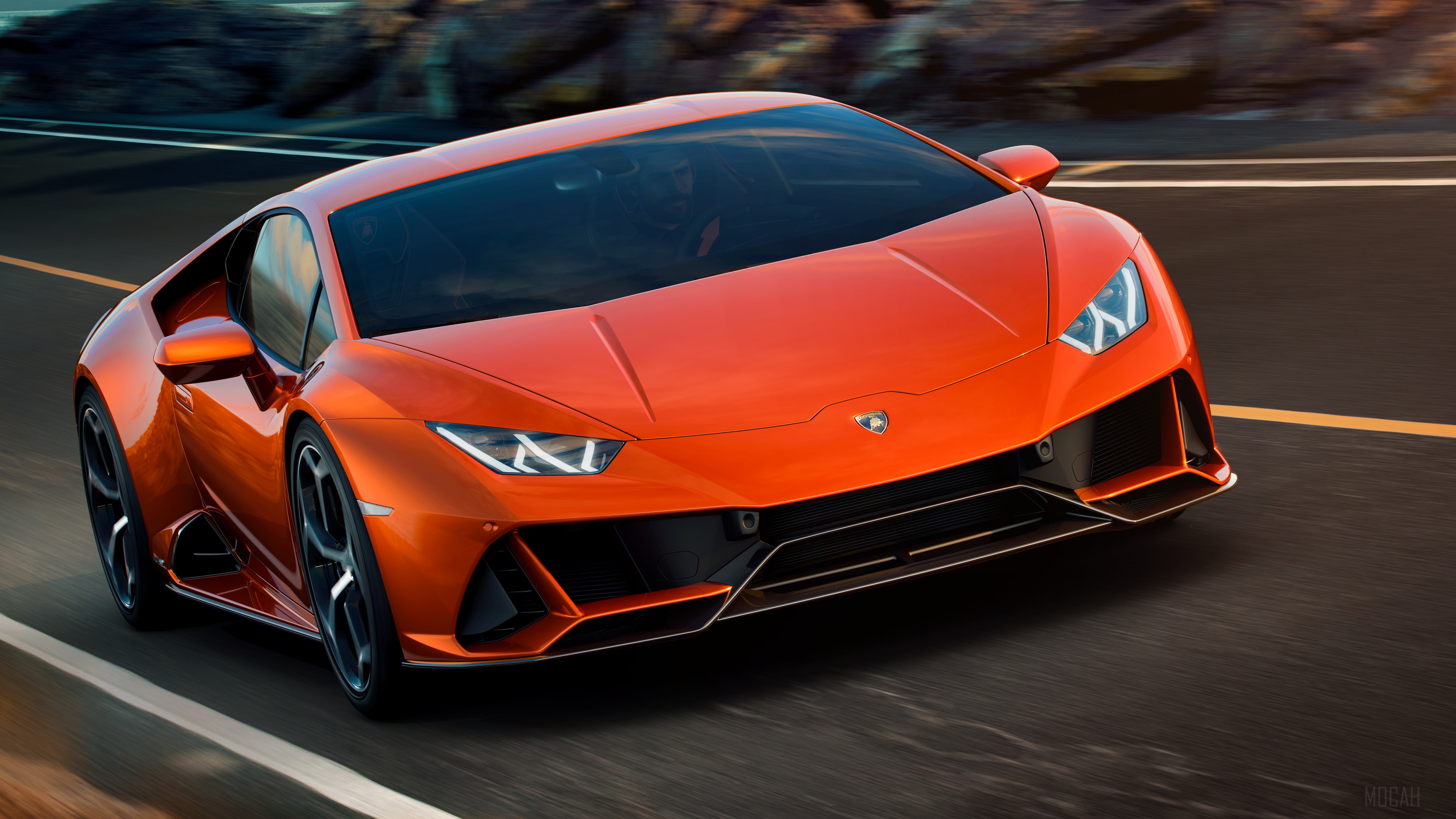 Orange Lamborghini Huracan EVO driving on a road HD Wallpaper