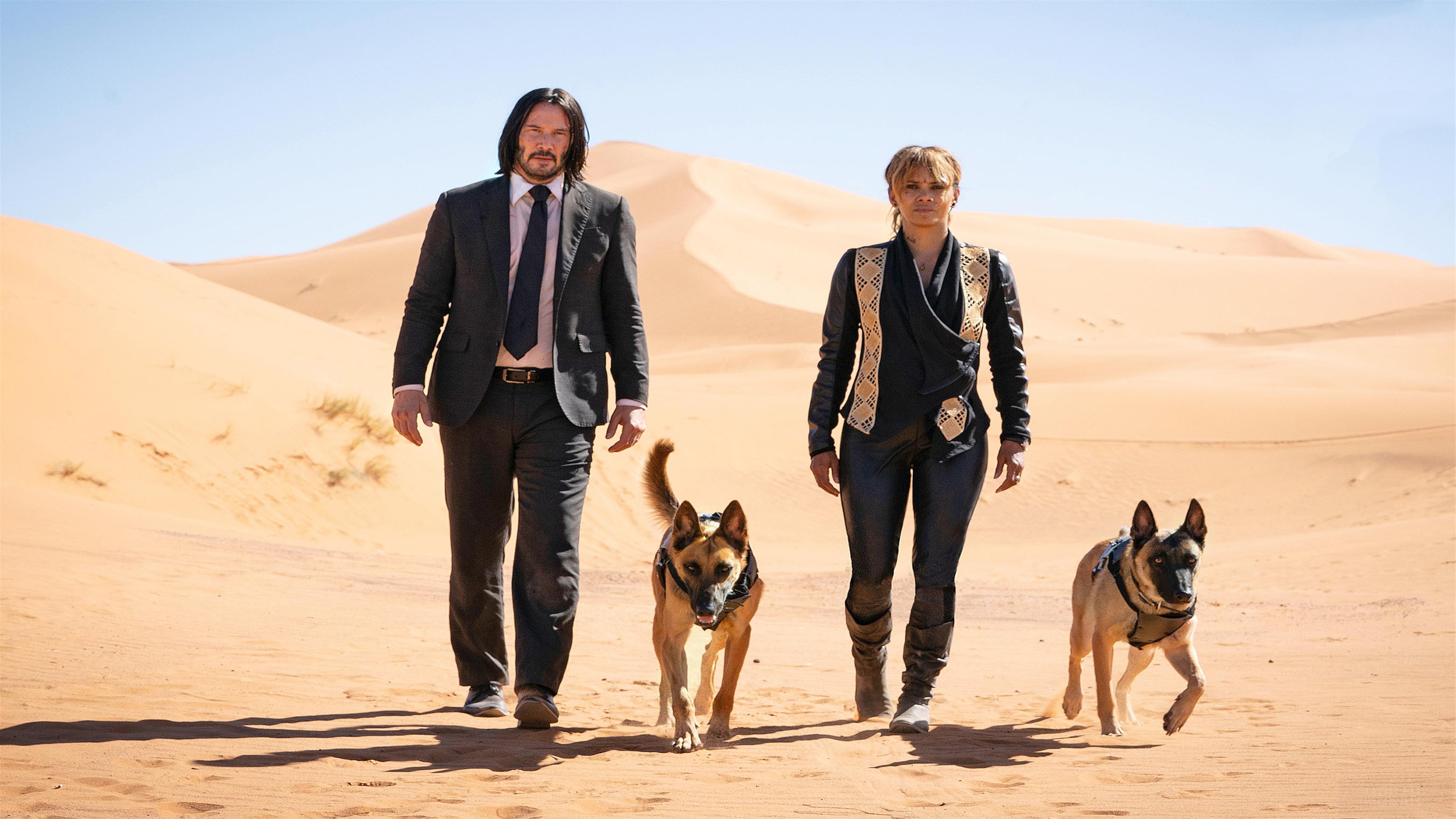 John Wick and Halle Berry with dogs in desert HD Wallpaper