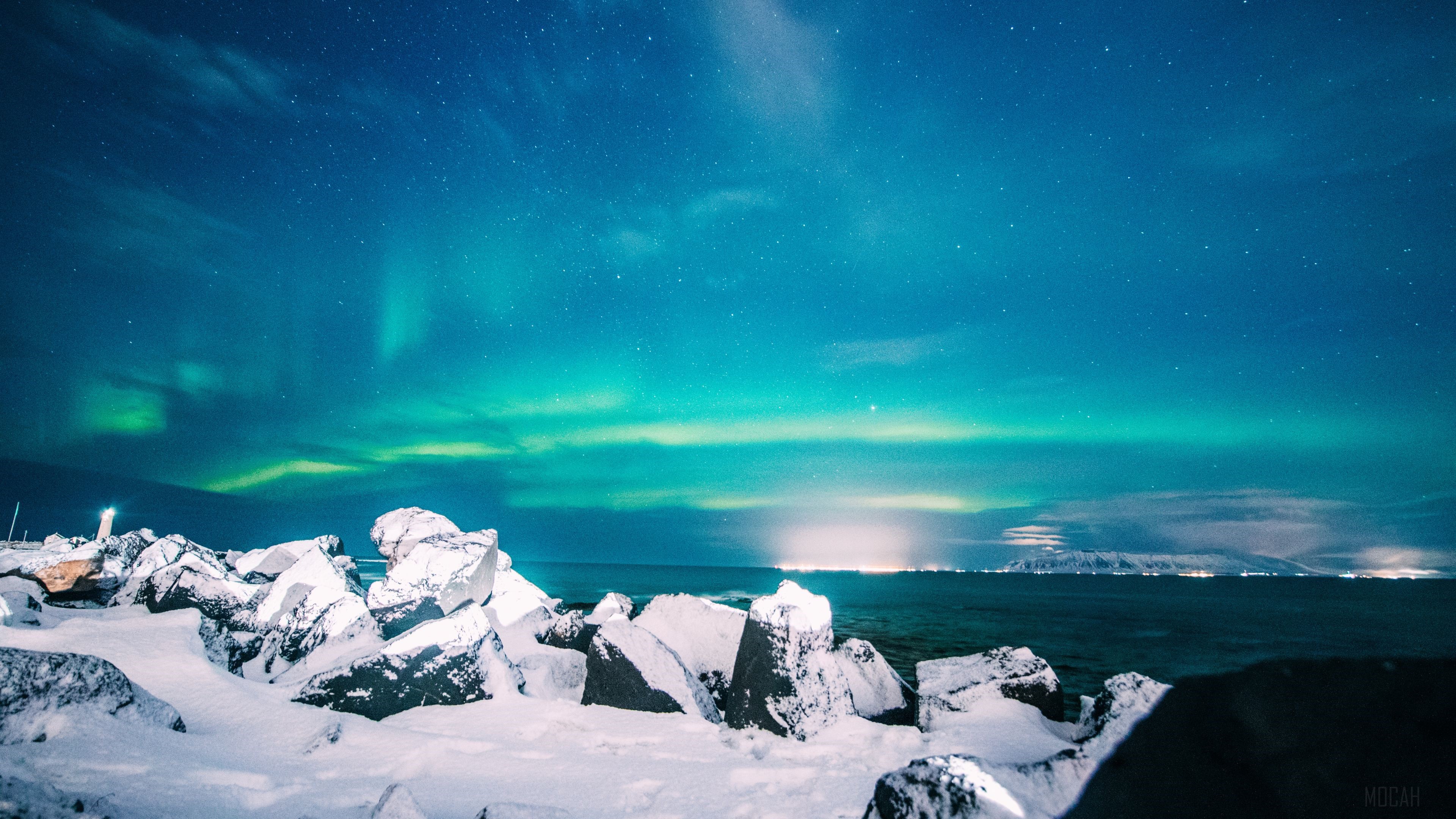 Northern Lights over snowy rocks and ocean HD Wallpaper