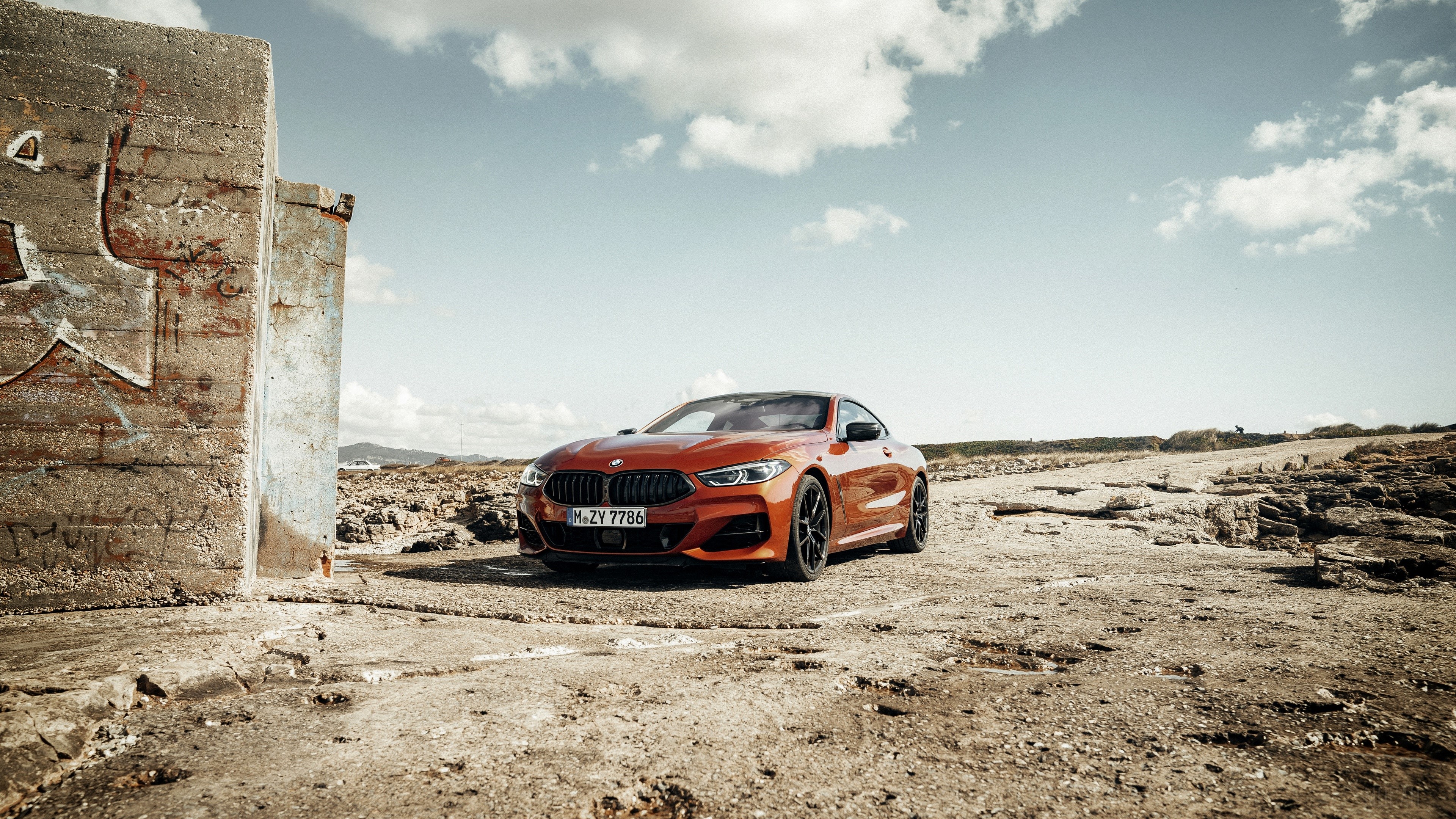 Orange BMW 8 Series Coupe on Rocky Terrain HD Wallpaper