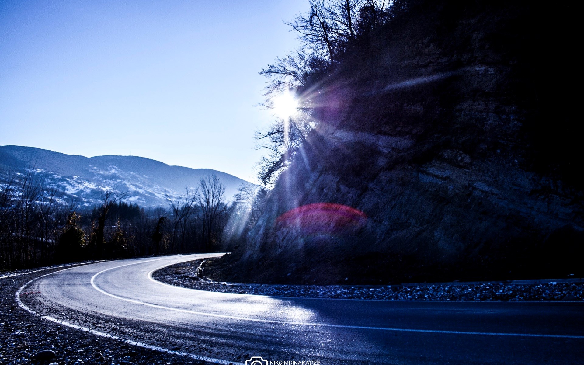 Winding mountain road with sun rays HD Wallpaper