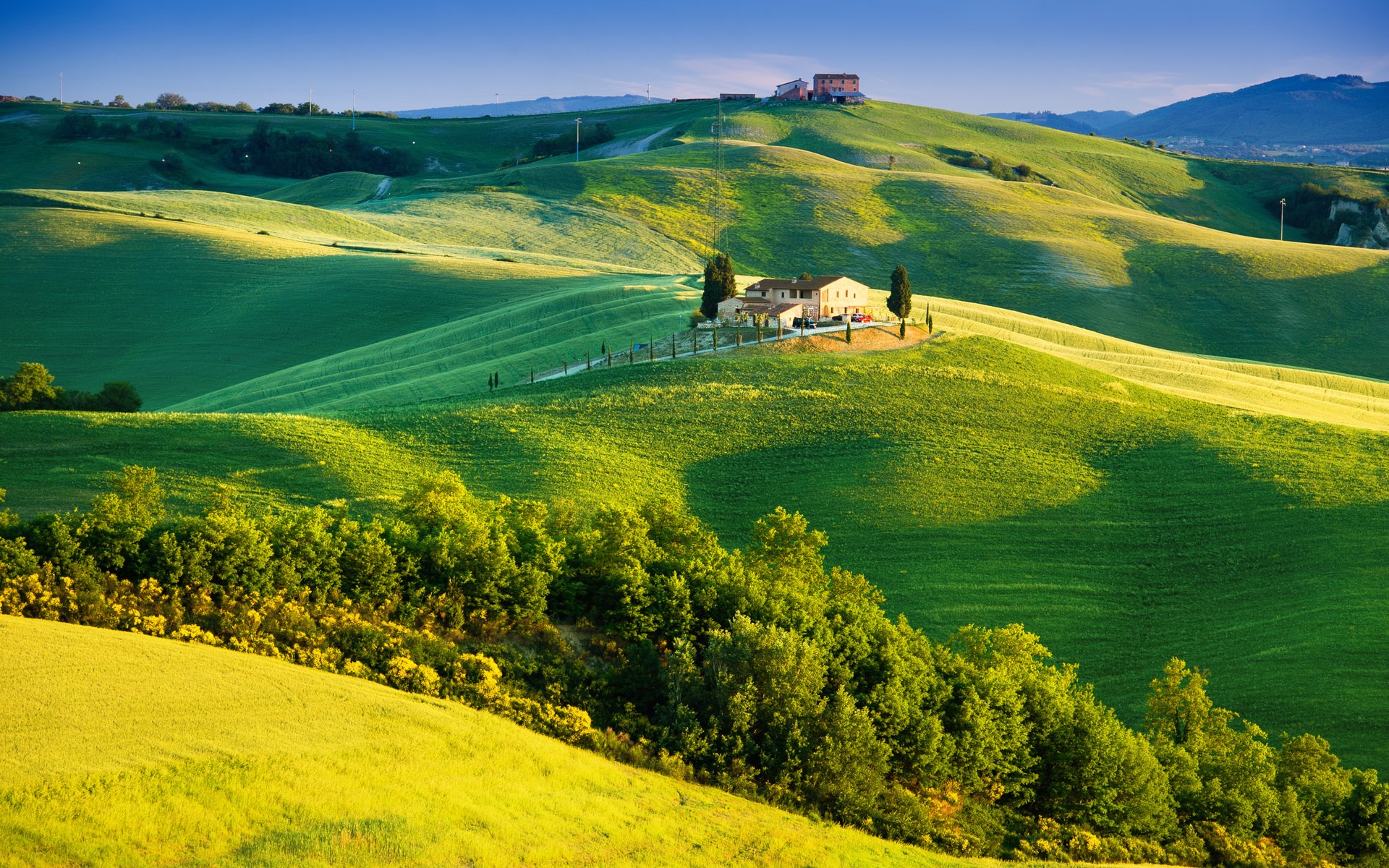 Tuscan landscape with rolling green hills and a farmhouse HD Wallpaper