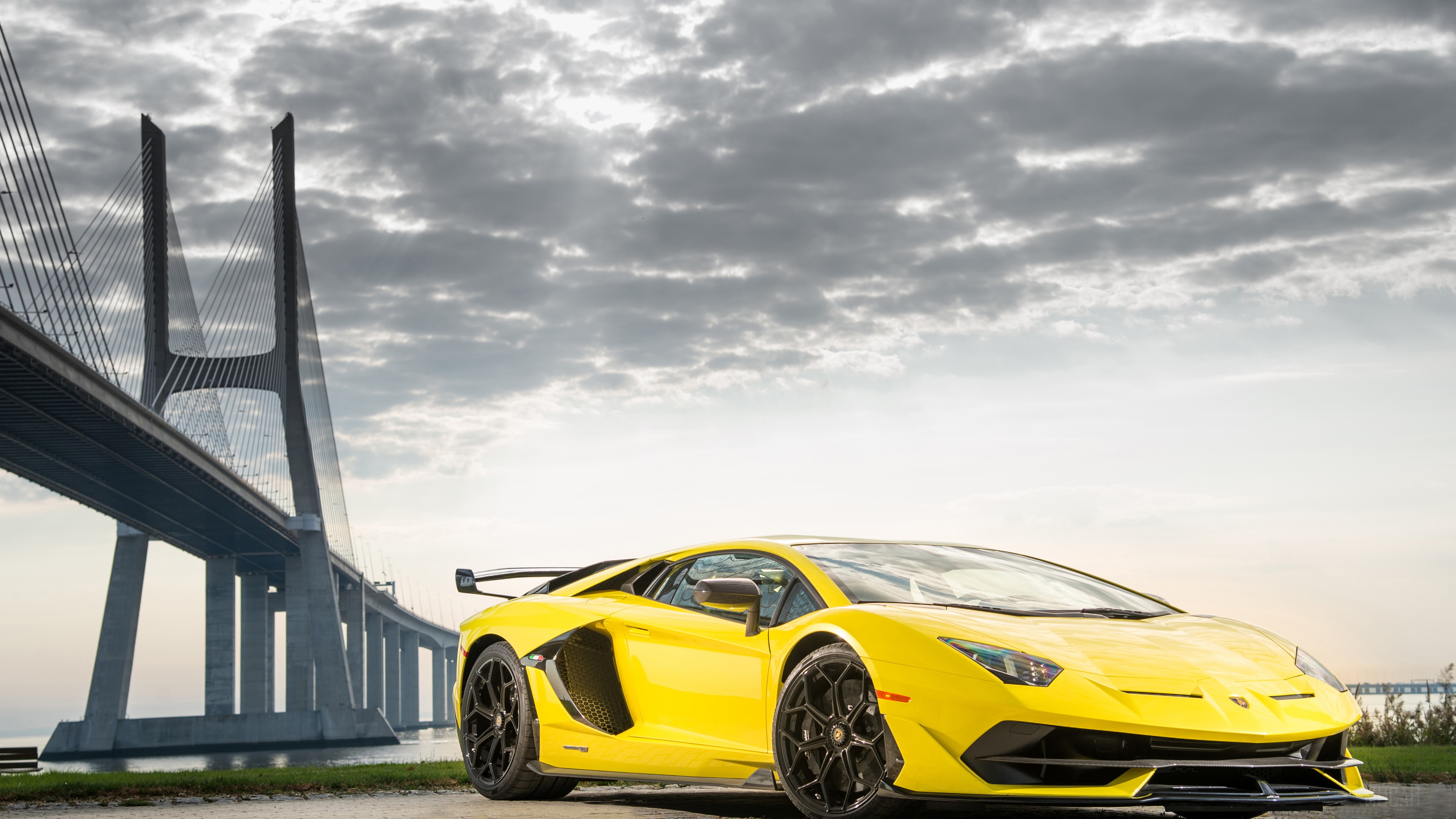 Yellow Lamborghini Aventador SVJ near Vasco da Gama Bridge HD Wallpaper