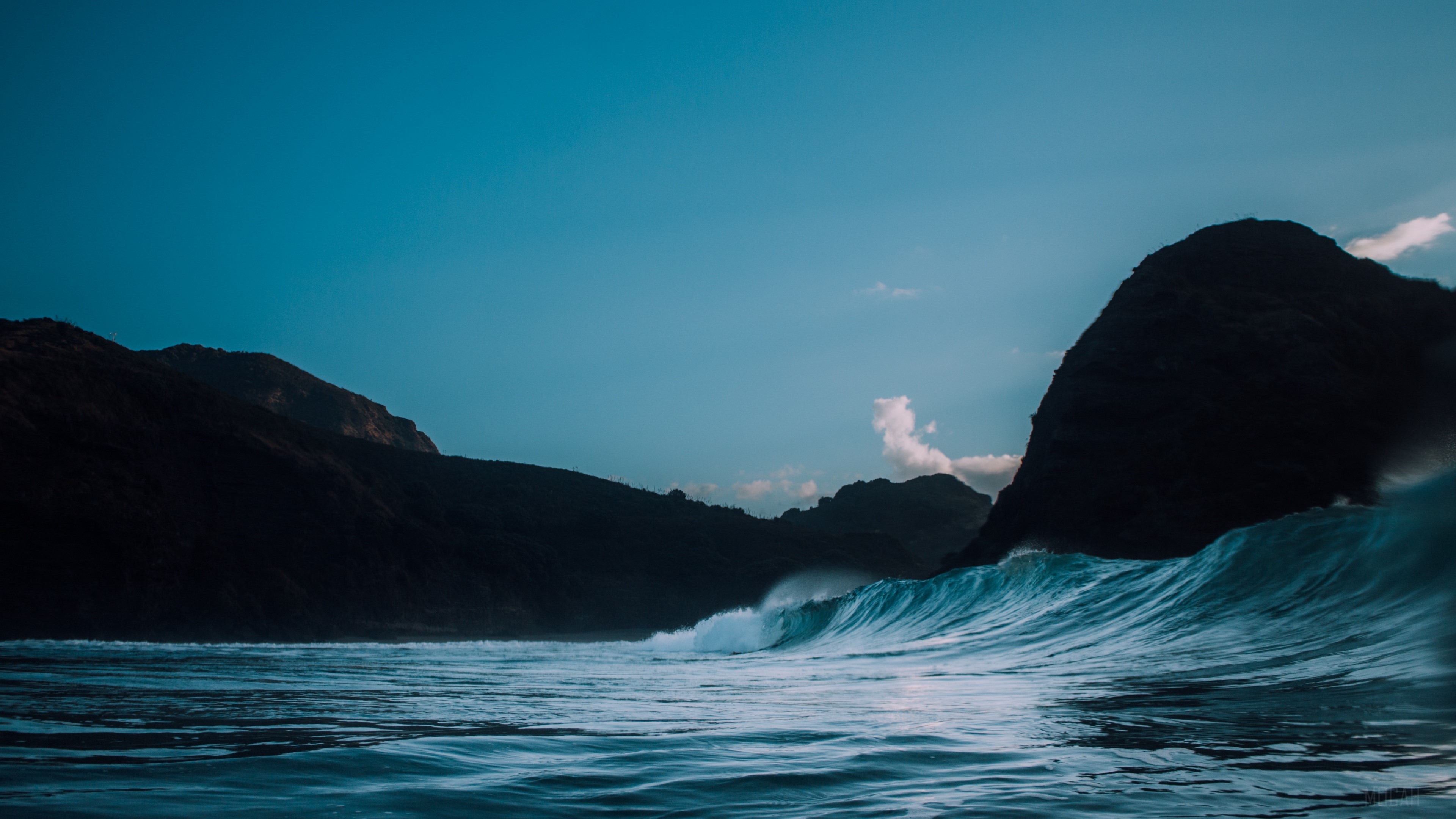 Wave crashing near dark rocks and mountains HD Wallpaper