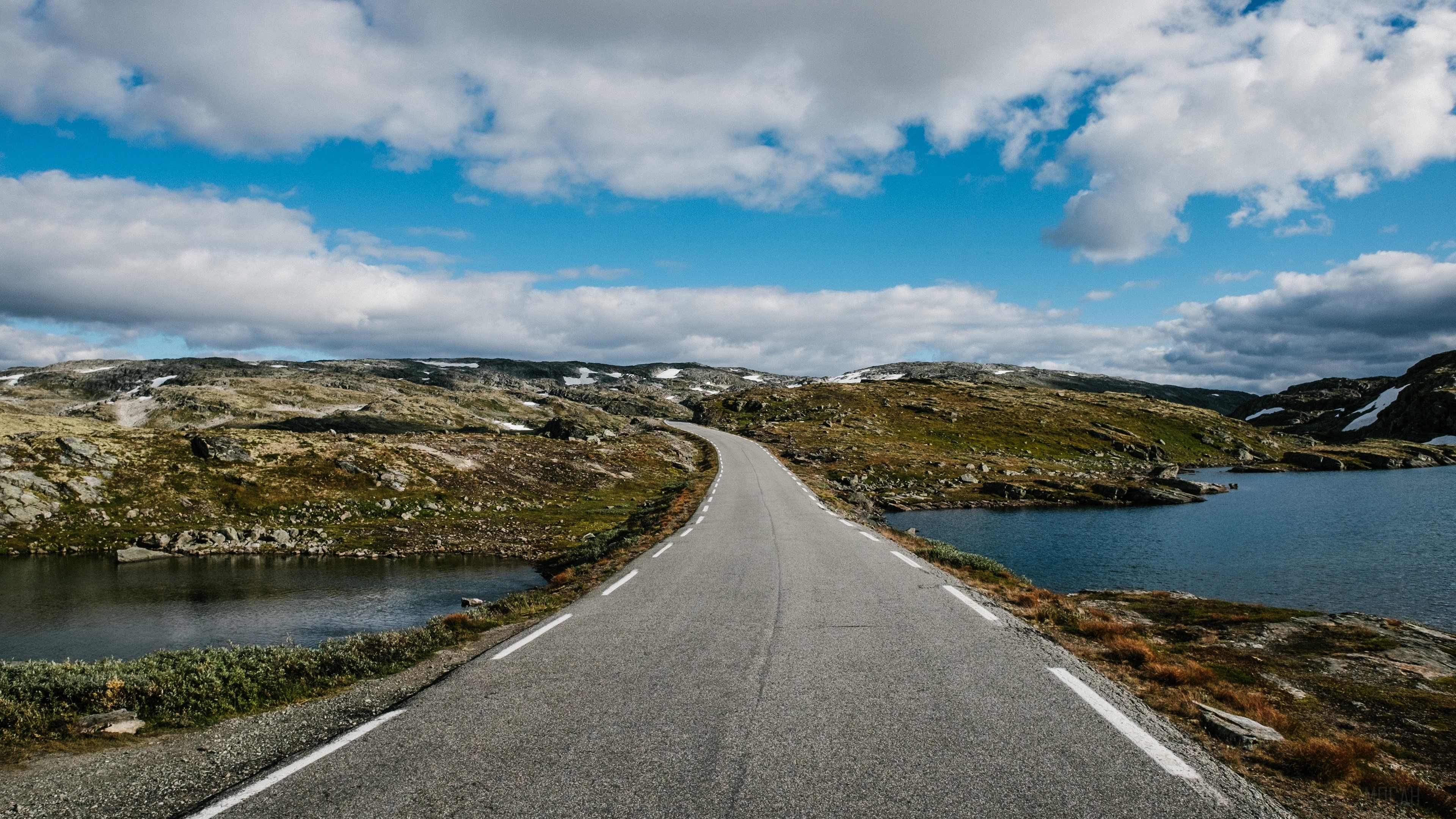 Road with markings in a mountainous landscape with lakes HD Wallpaper