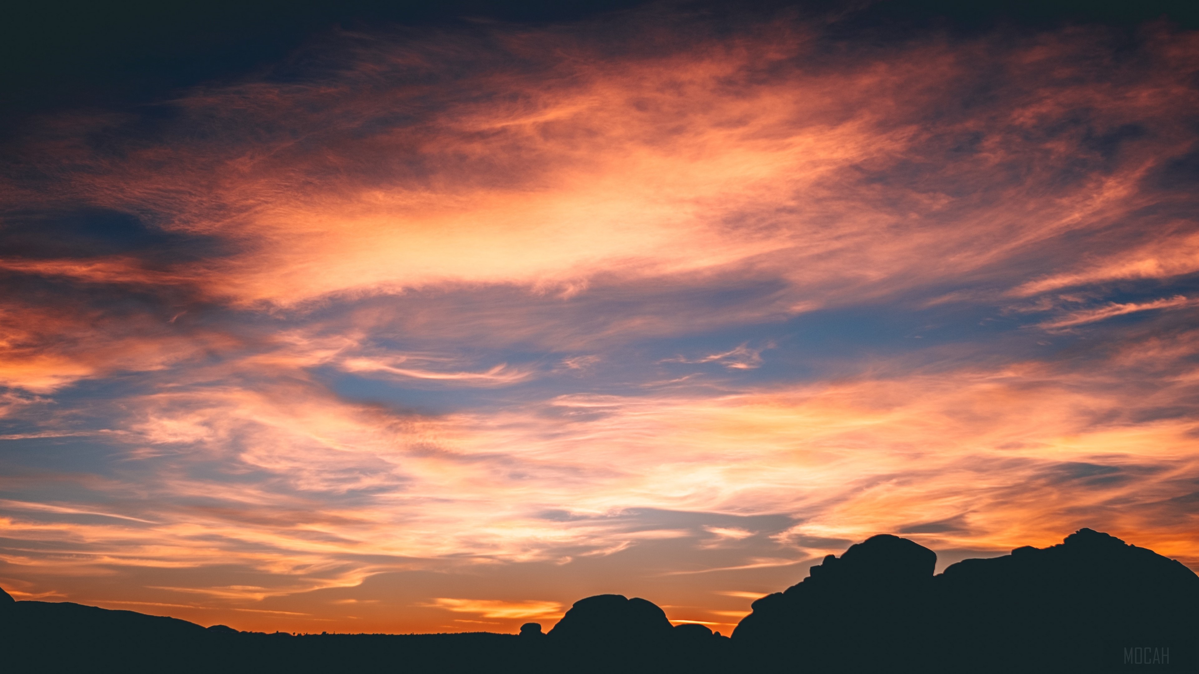 Silhouette of rocks against a dramatic sunset sky with clouds 4K HD Wallpaper