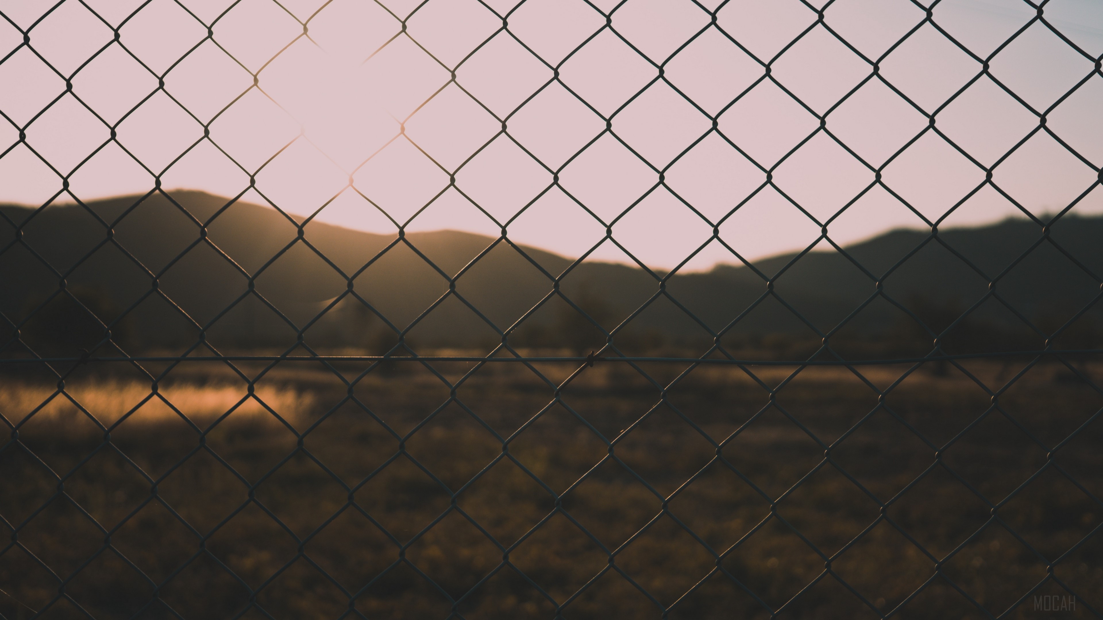 Fence in front of mountains at sunset HD Wallpaper