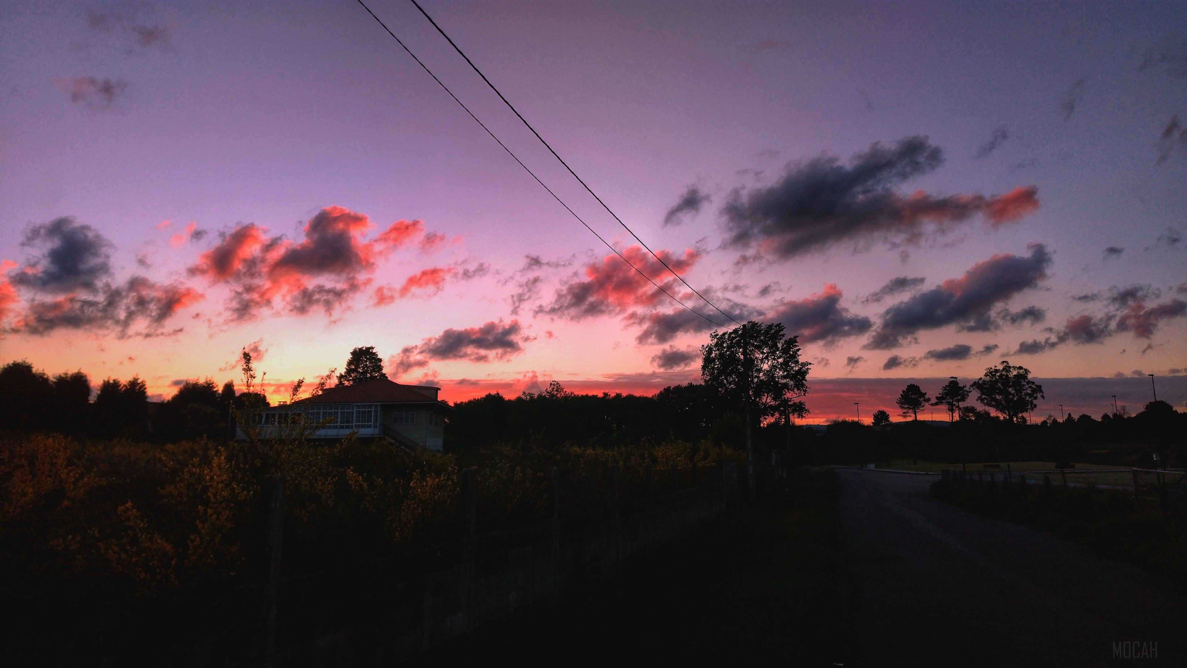 Sunset over a rural landscape with a house and road HD Wallpaper