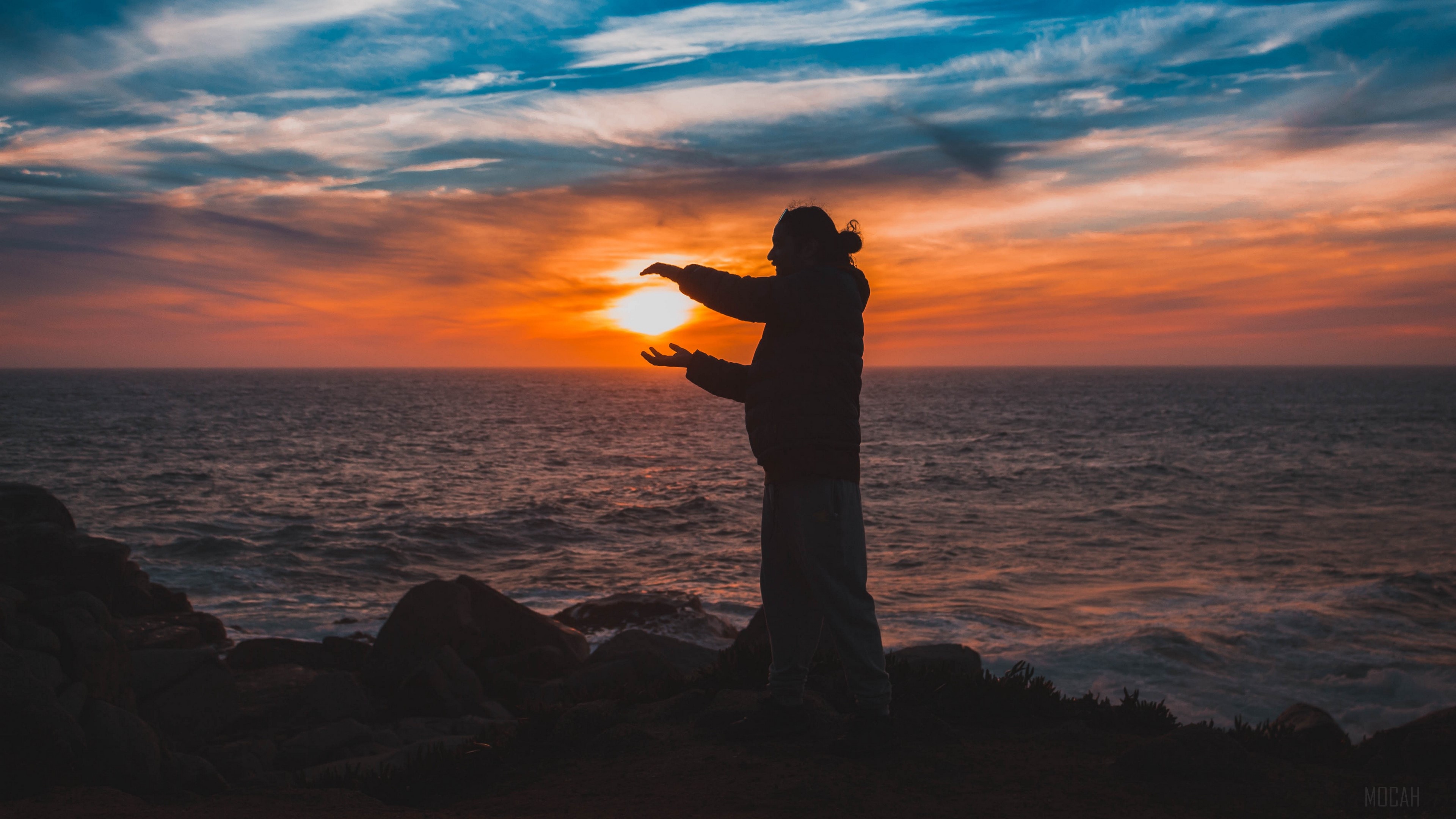 Man holding the sun at sunset over the sea 4K HD Wallpaper