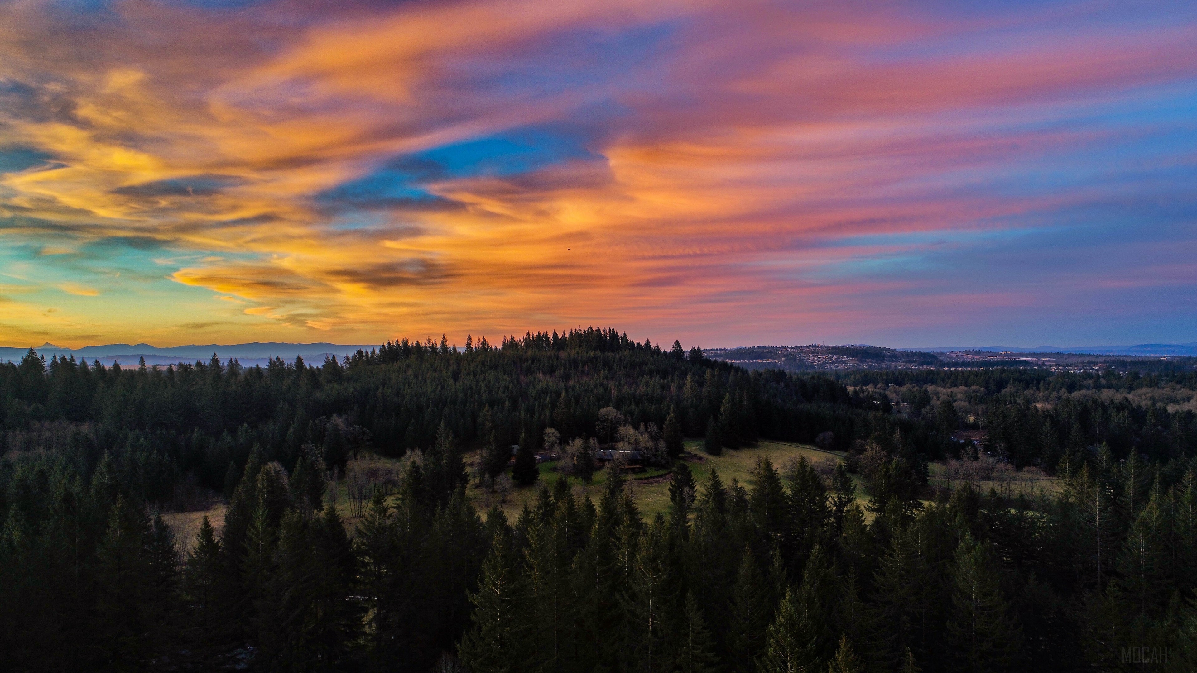 Sunset over forested hills and distant mountains 4K HD Wallpaper