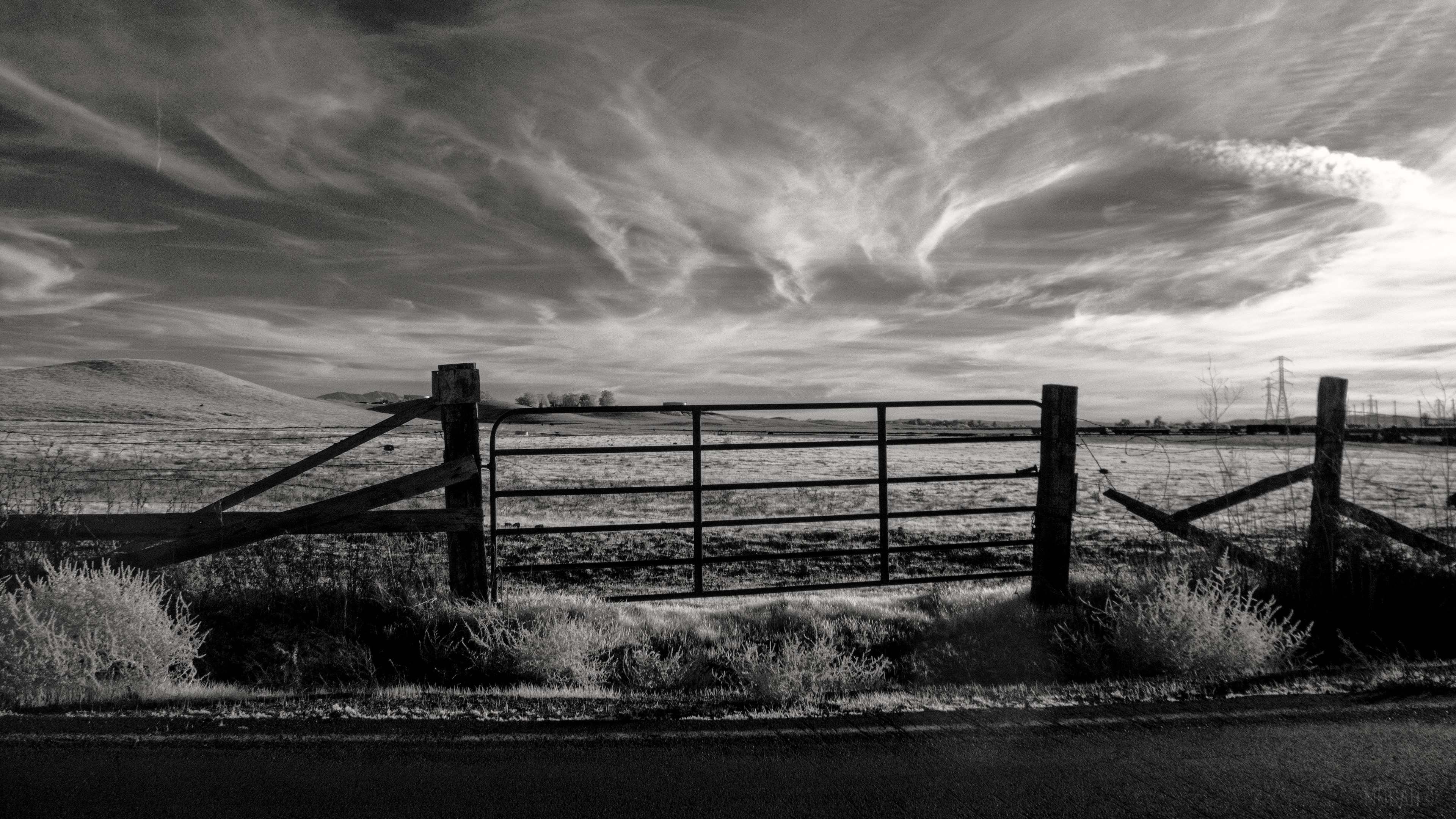 Black and white farm gate with dramatic sky HD Wallpaper