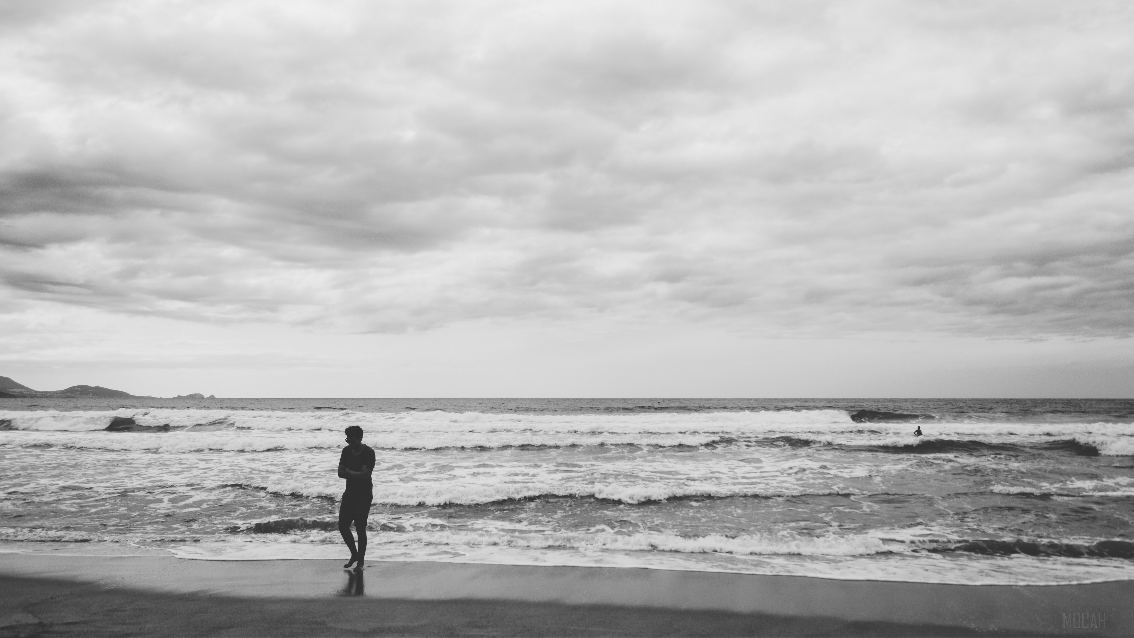 Man on beach with waves and cloudy sky HD Wallpaper