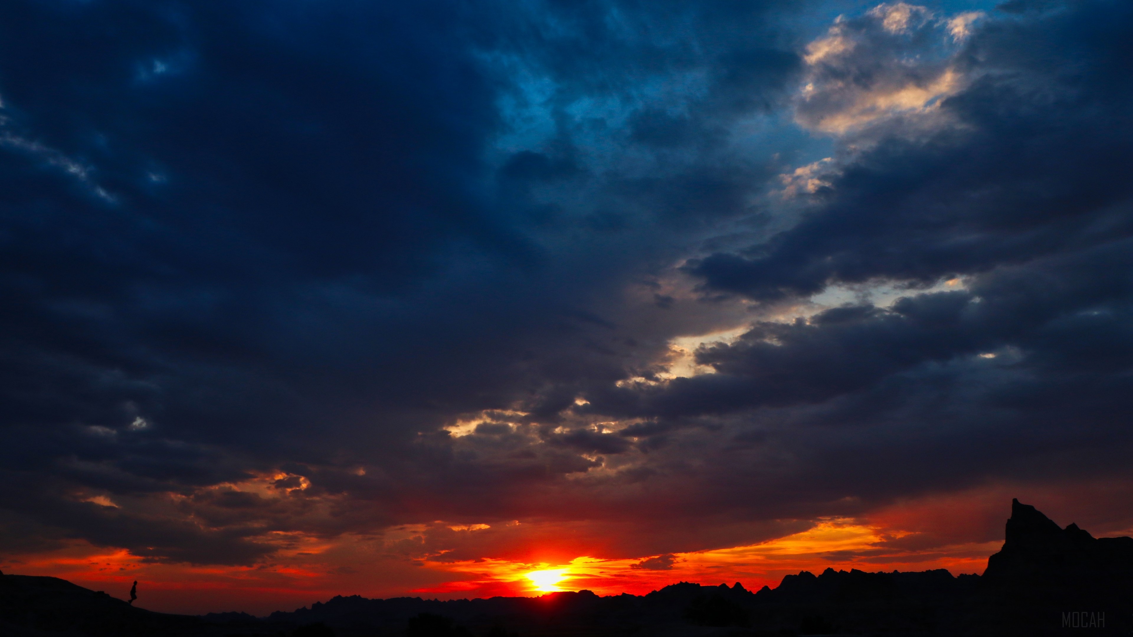 Sunset over Badlands with lone figure HD Wallpaper