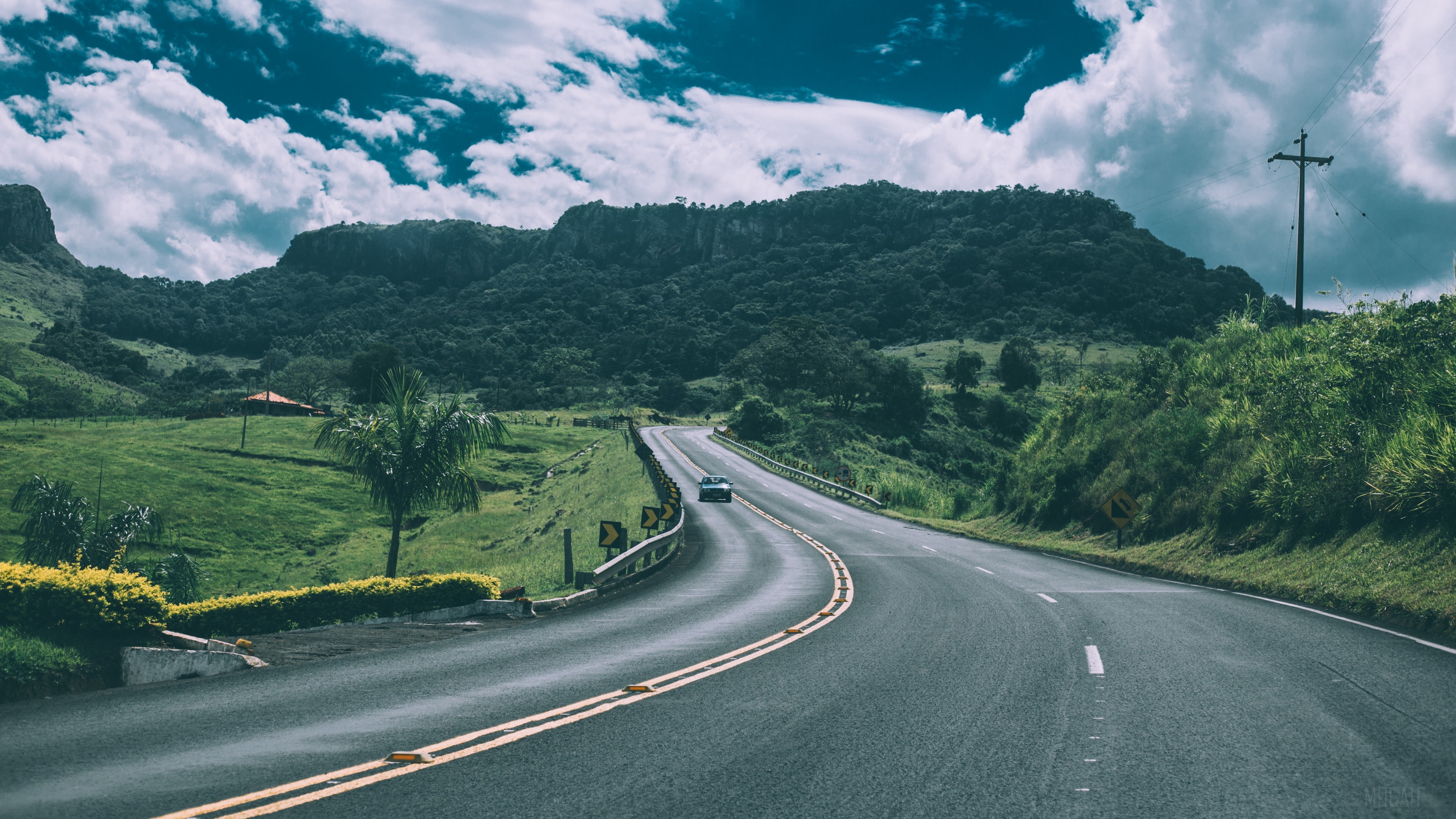 Car on a winding road through mountains 4K HD Wallpaper