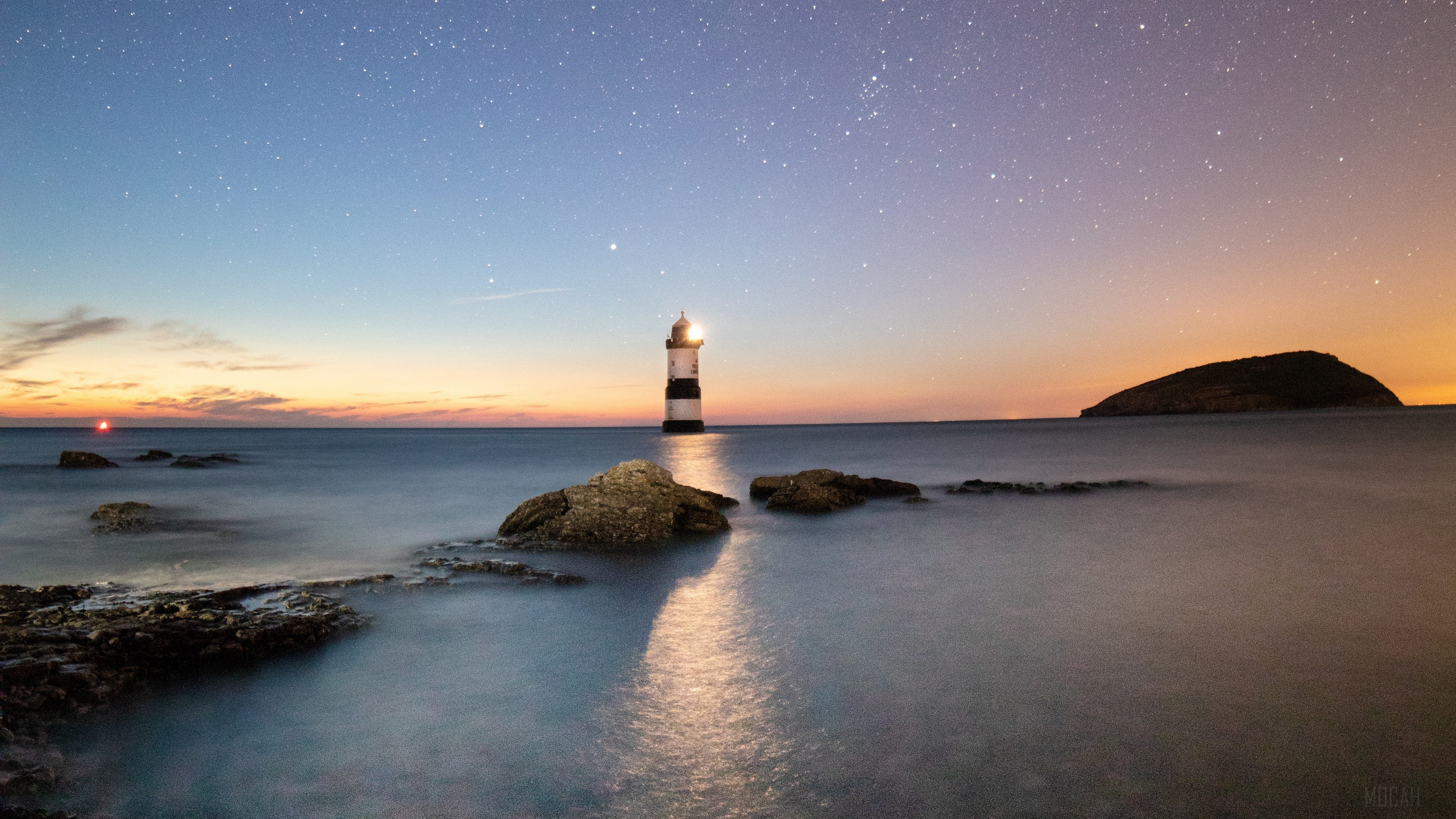 Penmon Lighthouse under a starry sky HD Wallpaper