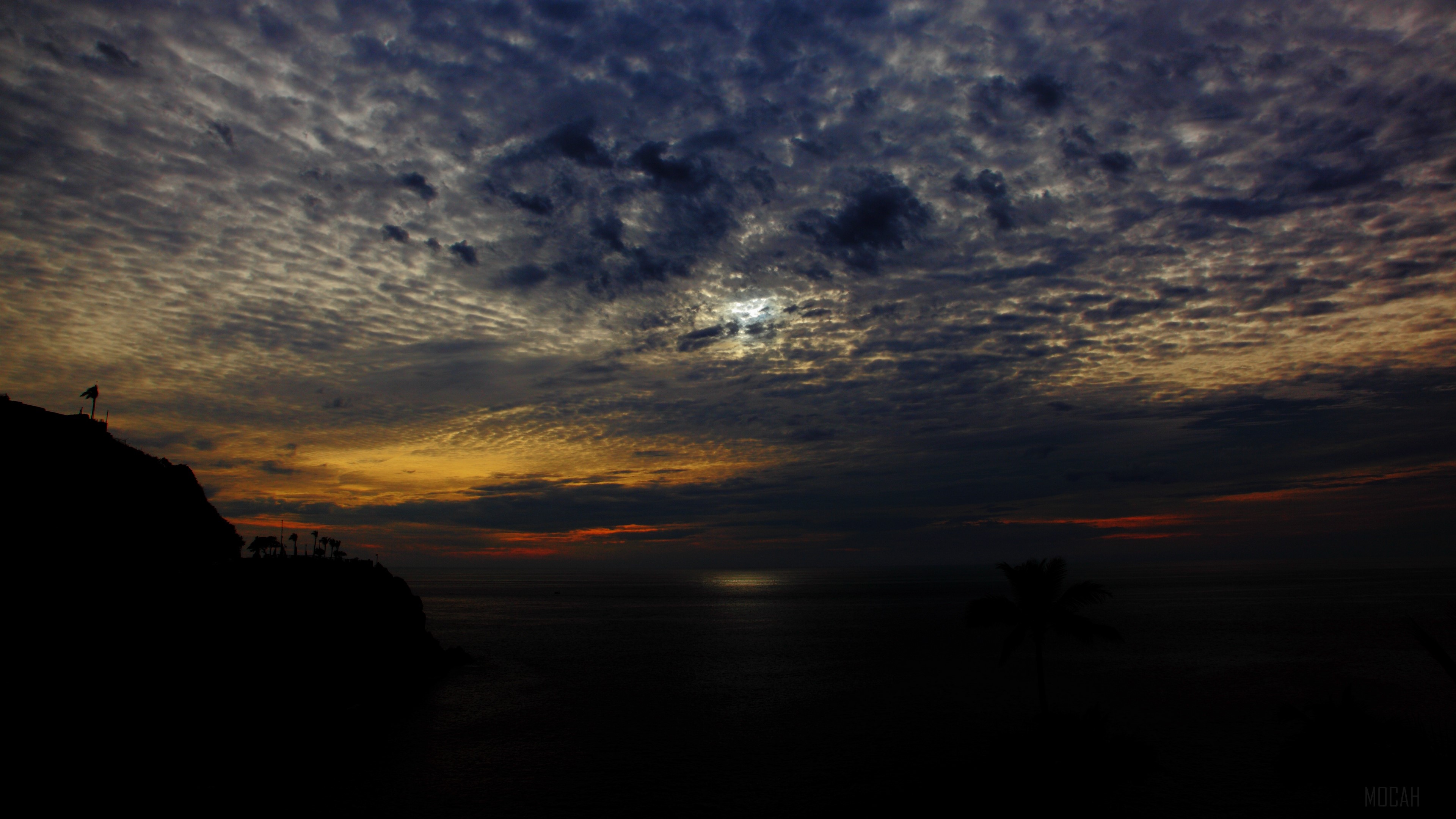 Sunset over the sea with clouds and silhouette of a hill HD Wallpaper