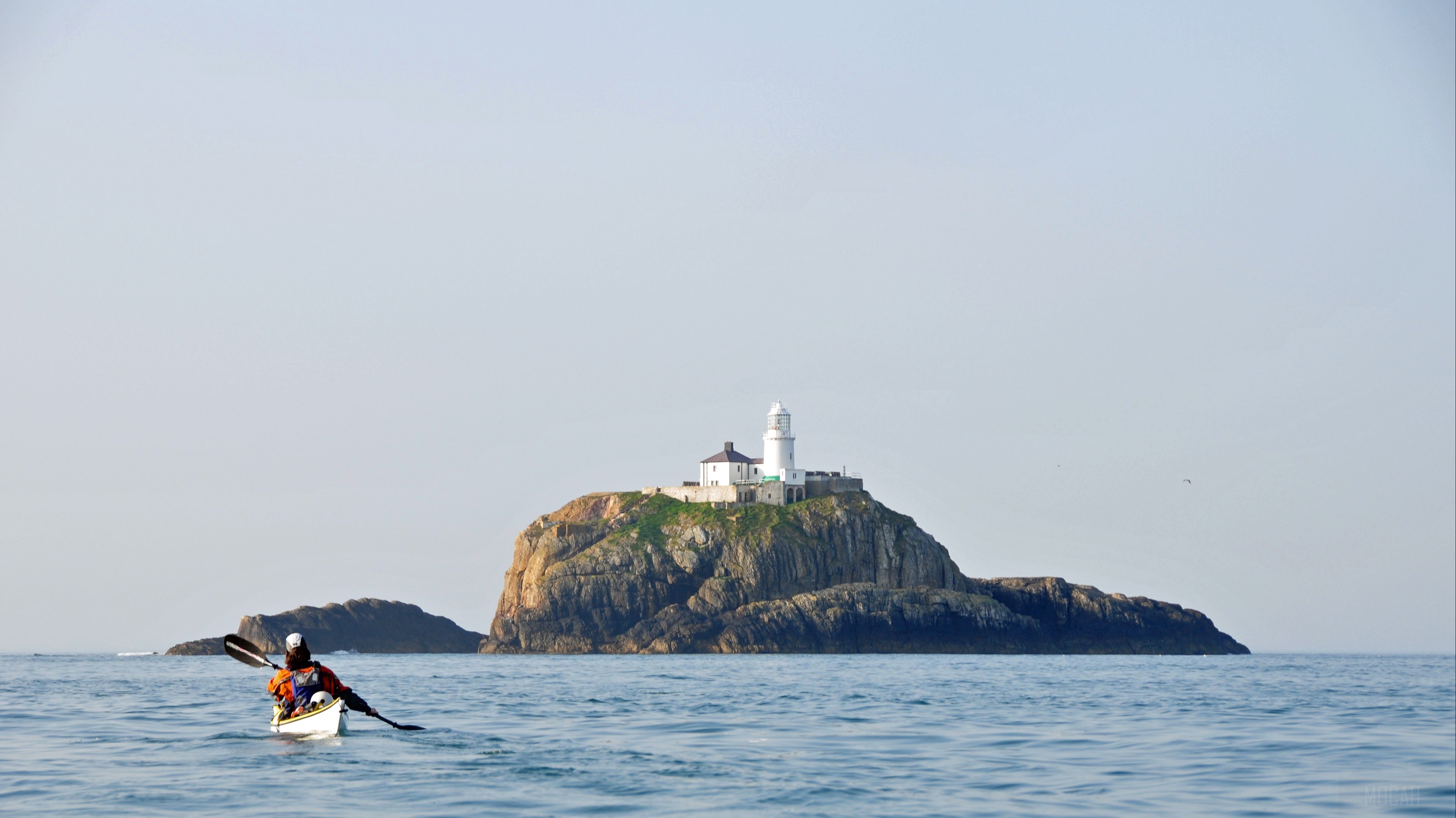 Kayaker approaches Bishop Rock Lighthouse on Scilly Isles HD Wallpaper