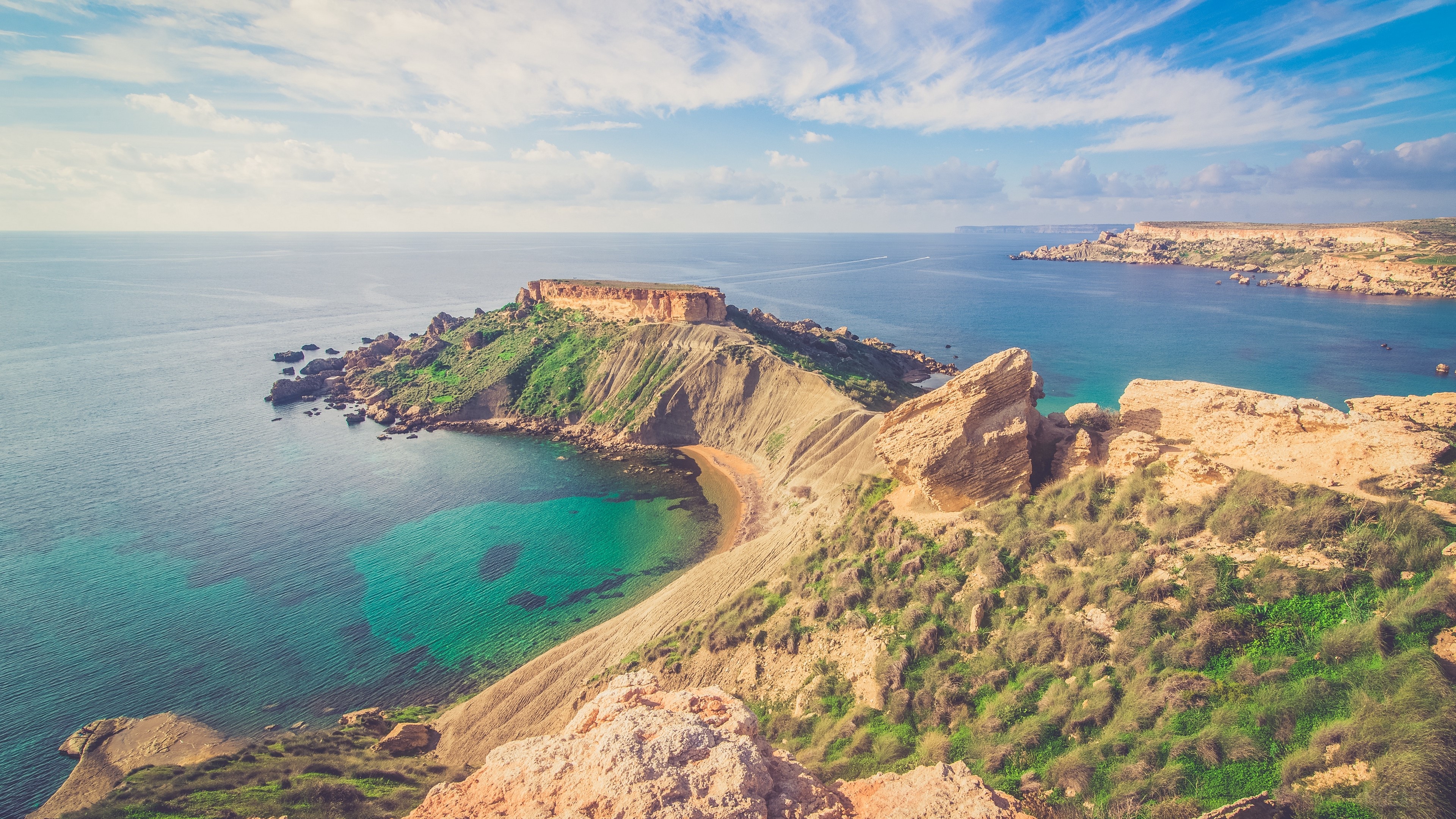 Rocky coastline with turquoise sea under a blue sky HD Wallpaper