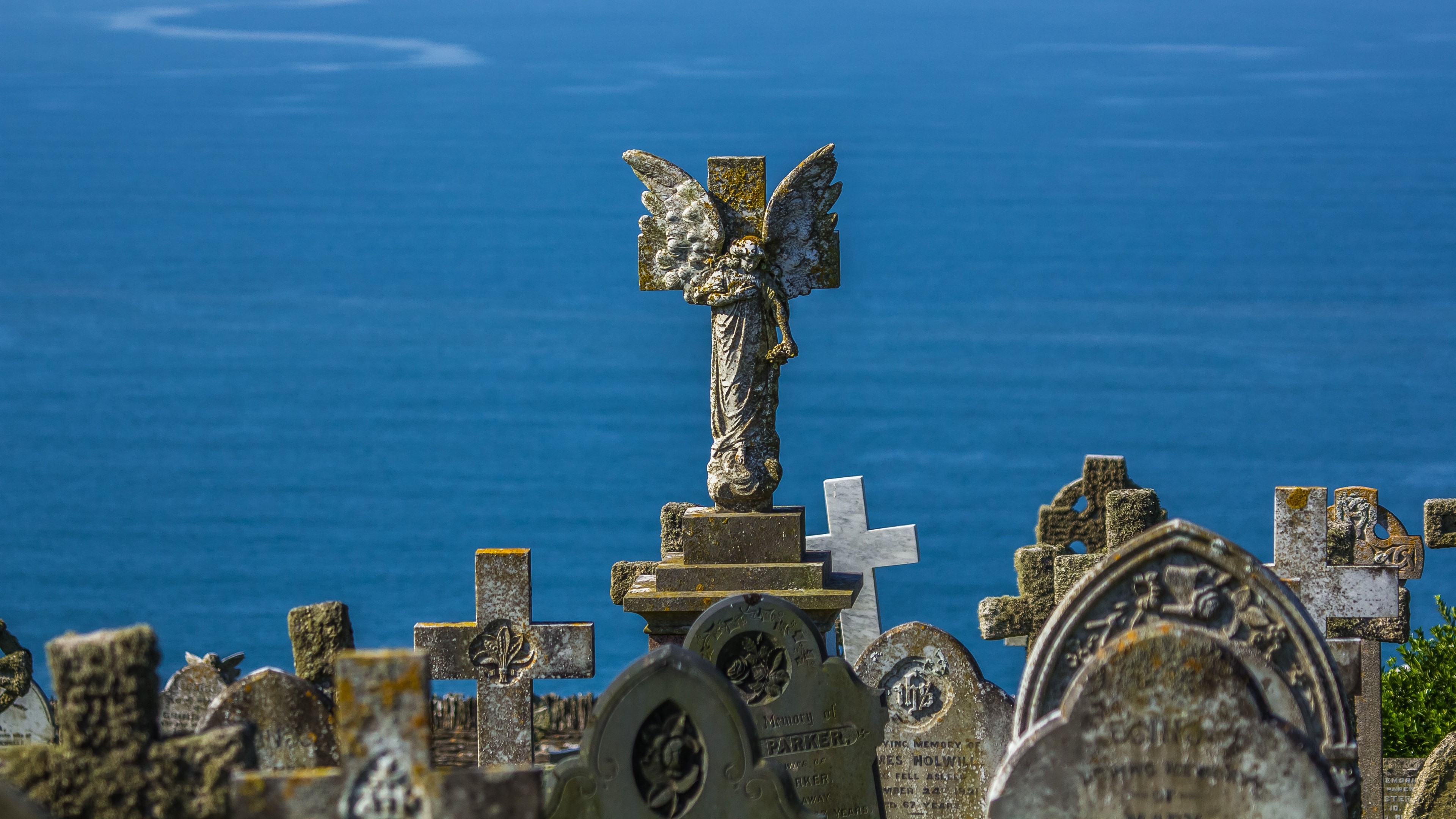 Angel sculpture on gravestones overlooking the sea HD Wallpaper