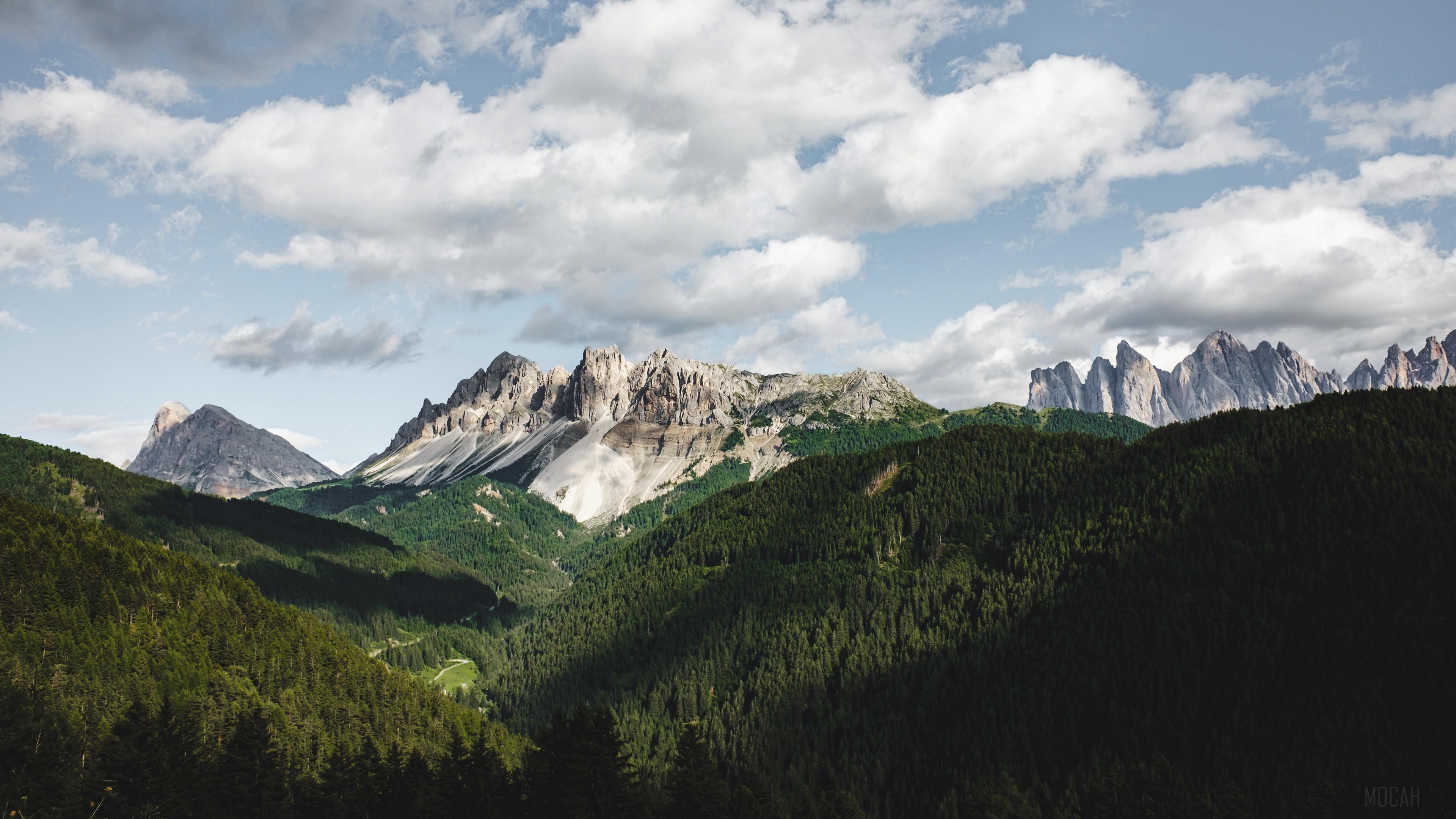 Mountains and forests under a cloudy sky HD Wallpaper