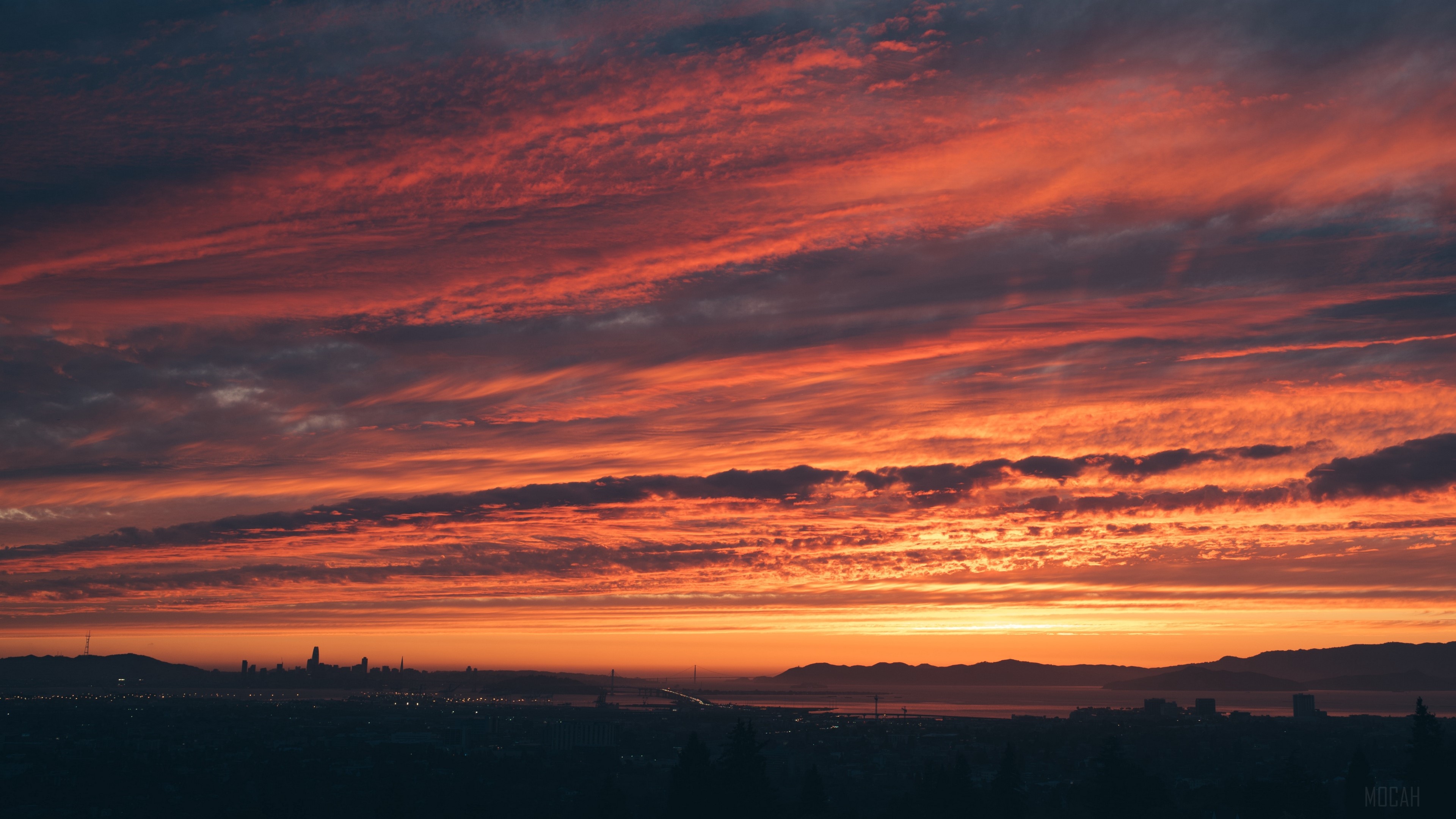 Sunset over city skyline with dramatic clouds HD Wallpaper
