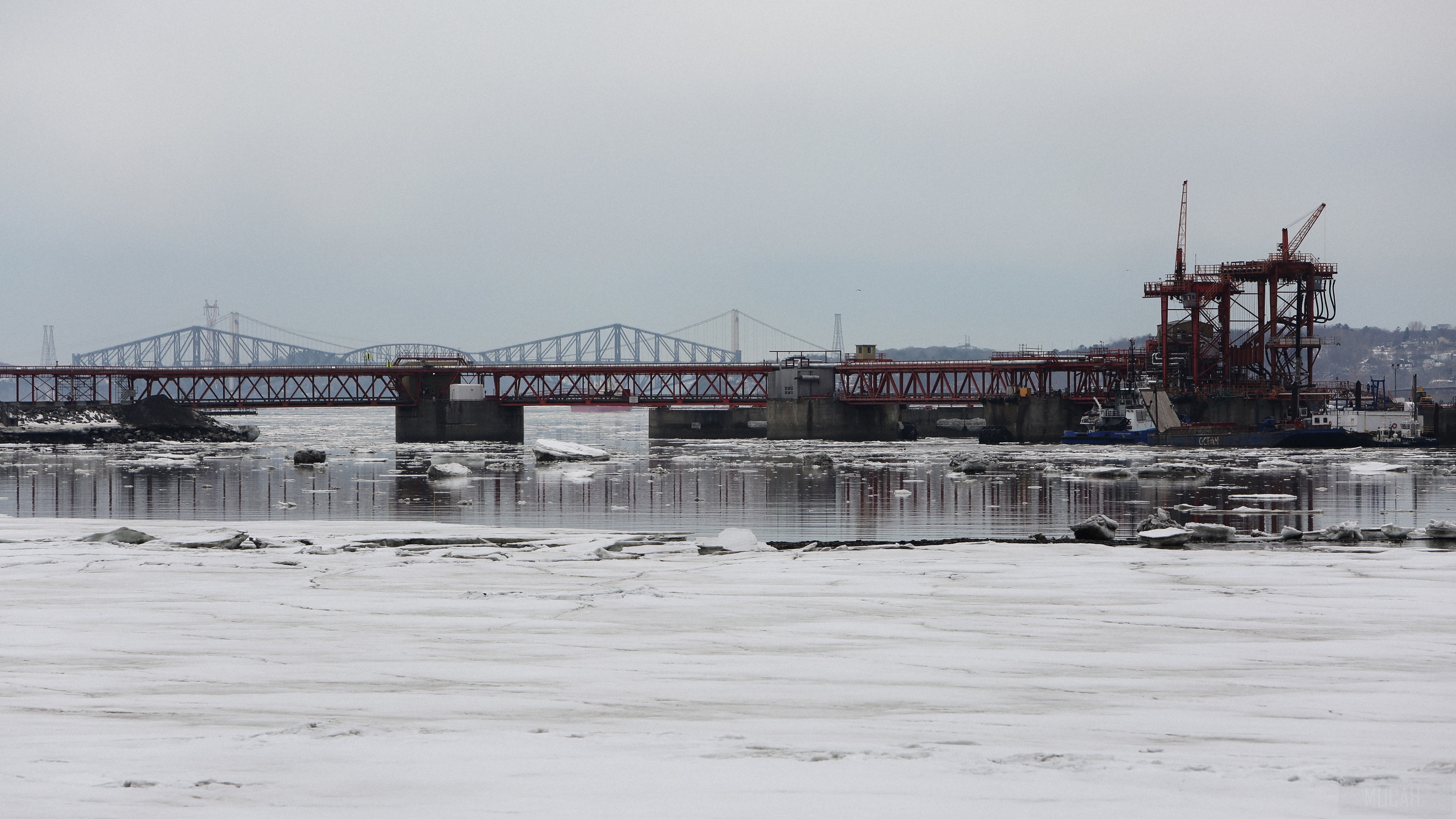 Bridges over a frozen river with construction cranes HD Wallpaper