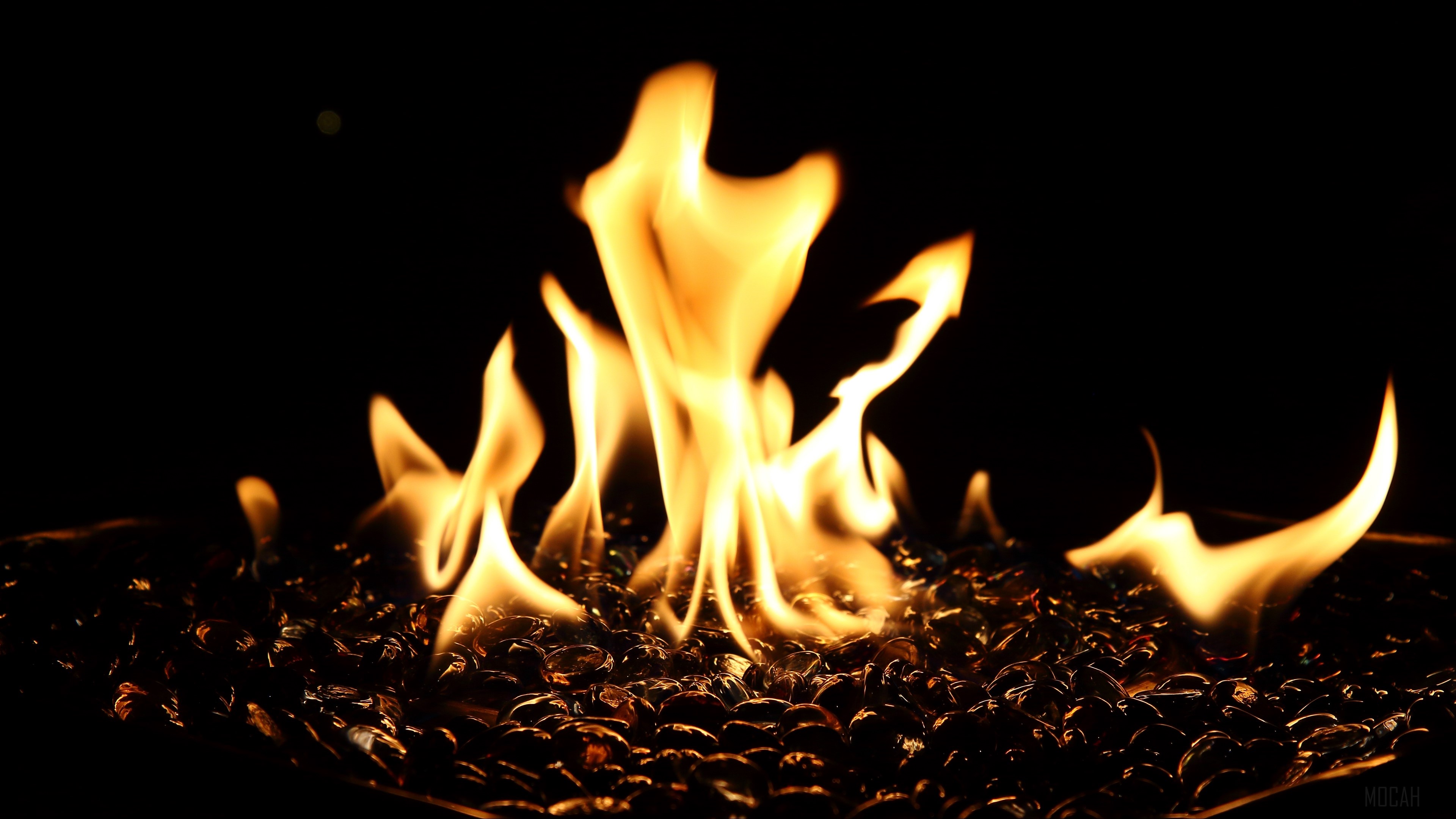 Fiery flames over dark glass rocks 4K HD Wallpaper