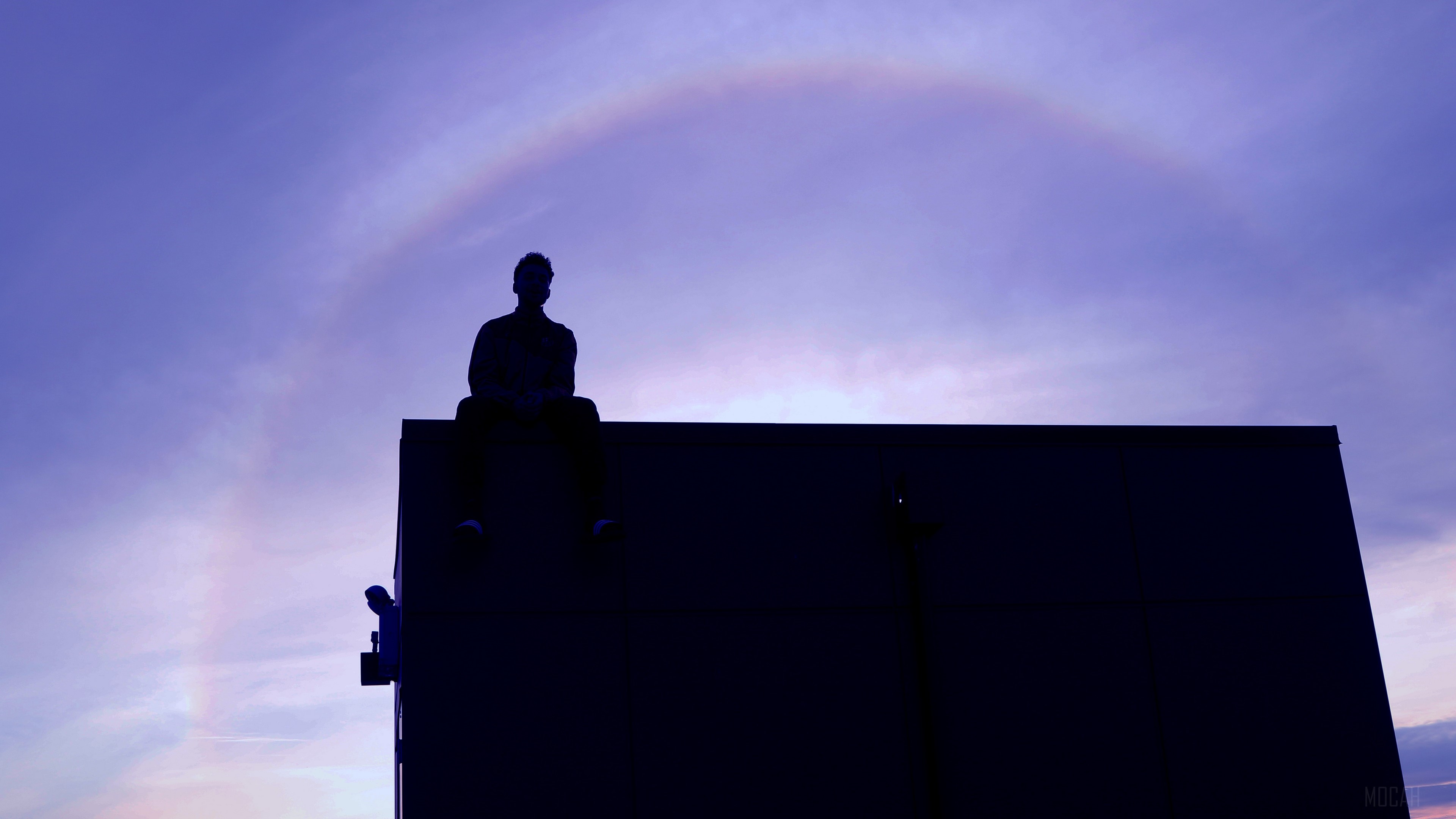 Man sitting on a roof at sunset with a halo HD Wallpaper
