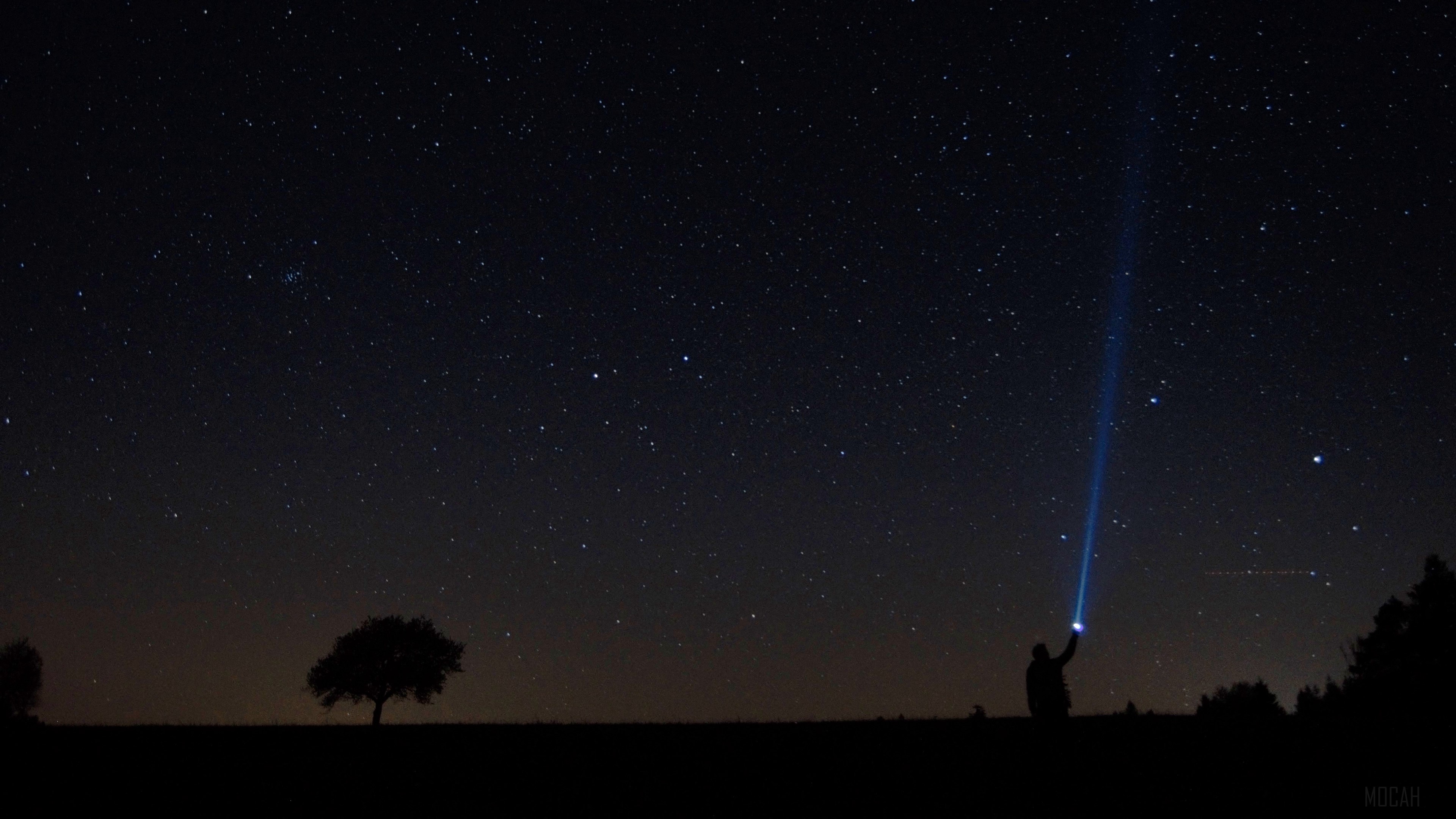 Man with flashlight under starry sky HD Wallpaper