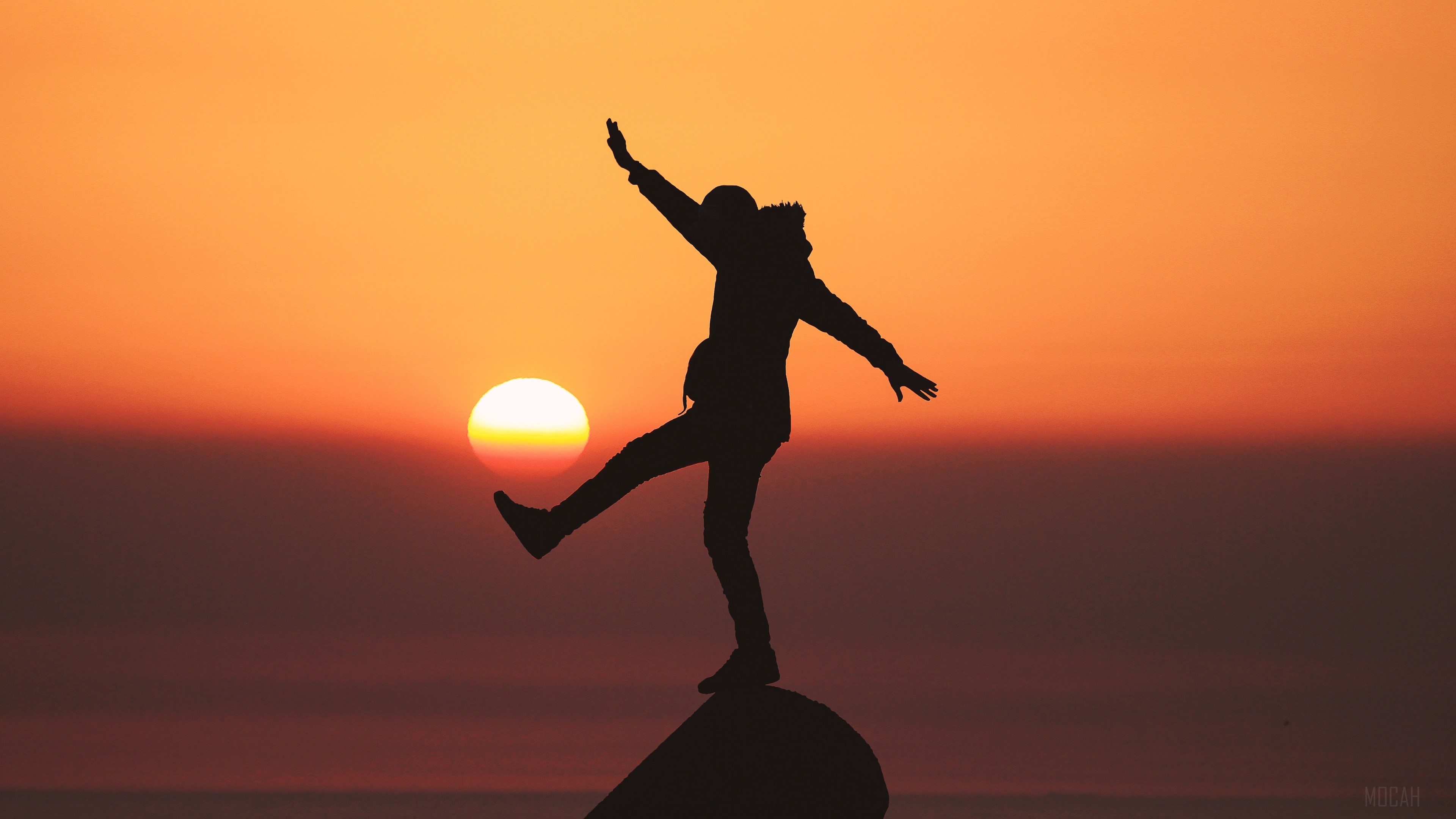Silhouette of a person balancing at sunset 4K HD Wallpaper