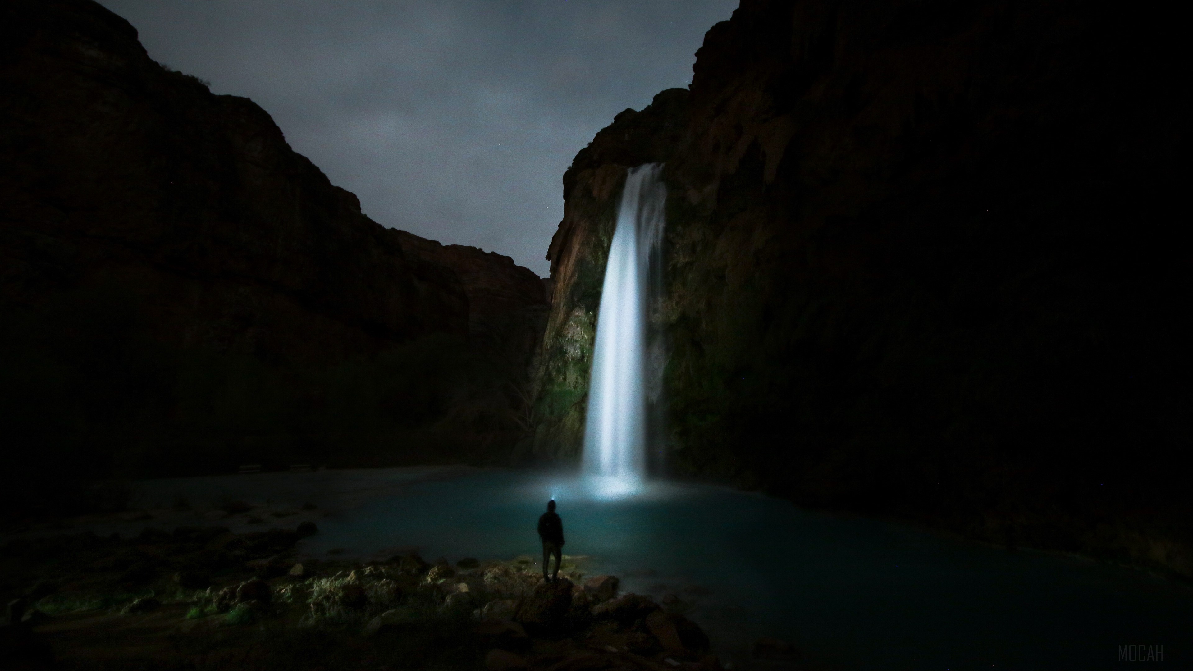 Man with headlamp at waterfall at night HD Wallpaper